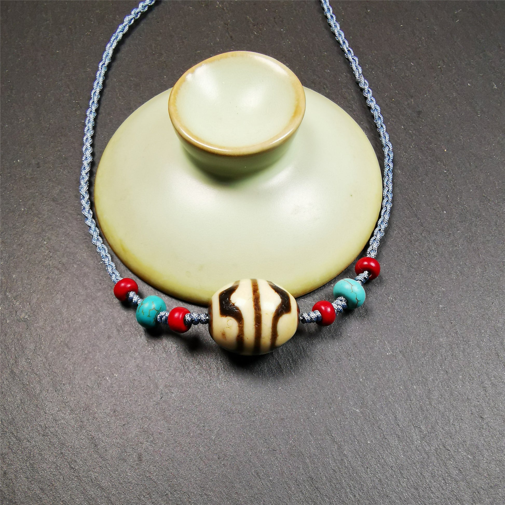 This necklace was hand-woven by Tibetans from Baiyu County, the main bead is a lotus dalo dzi bead, paired with turquoise and agate beads,about 40 years old. It can be worn not only as a fashionable accessory but also holds cultural and religious significance. The length of the necklace can be adjusted, the maximum circumference is about 60cm.