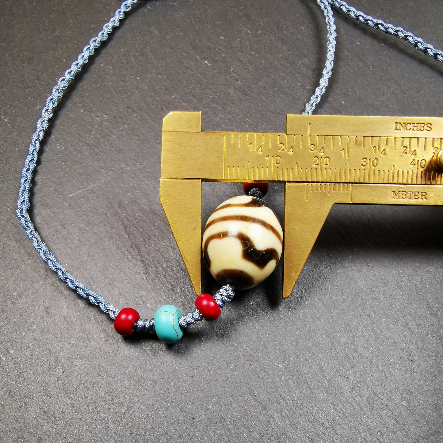 This necklace was hand-woven by Tibetans from Baiyu County, the main bead is a lotus dalo dzi bead, paired with turquoise and agate beads,about 40 years old. It can be worn not only as a fashionable accessory but also holds cultural and religious significance. The length of the necklace can be adjusted, the maximum circumference is about 60cm.