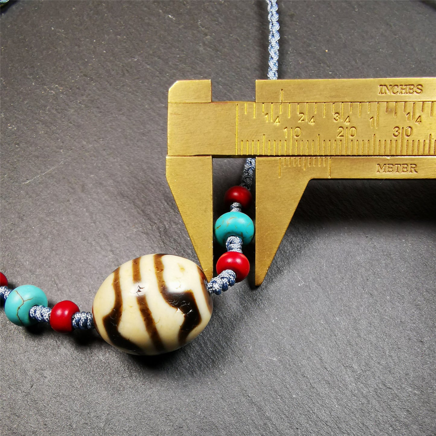 This necklace was hand-woven by Tibetans from Baiyu County, the main bead is a lotus dalo dzi bead, paired with turquoise and agate beads,about 40 years old. It can be worn not only as a fashionable accessory but also holds cultural and religious significance. The length of the necklace can be adjusted, the maximum circumference is about 60cm.