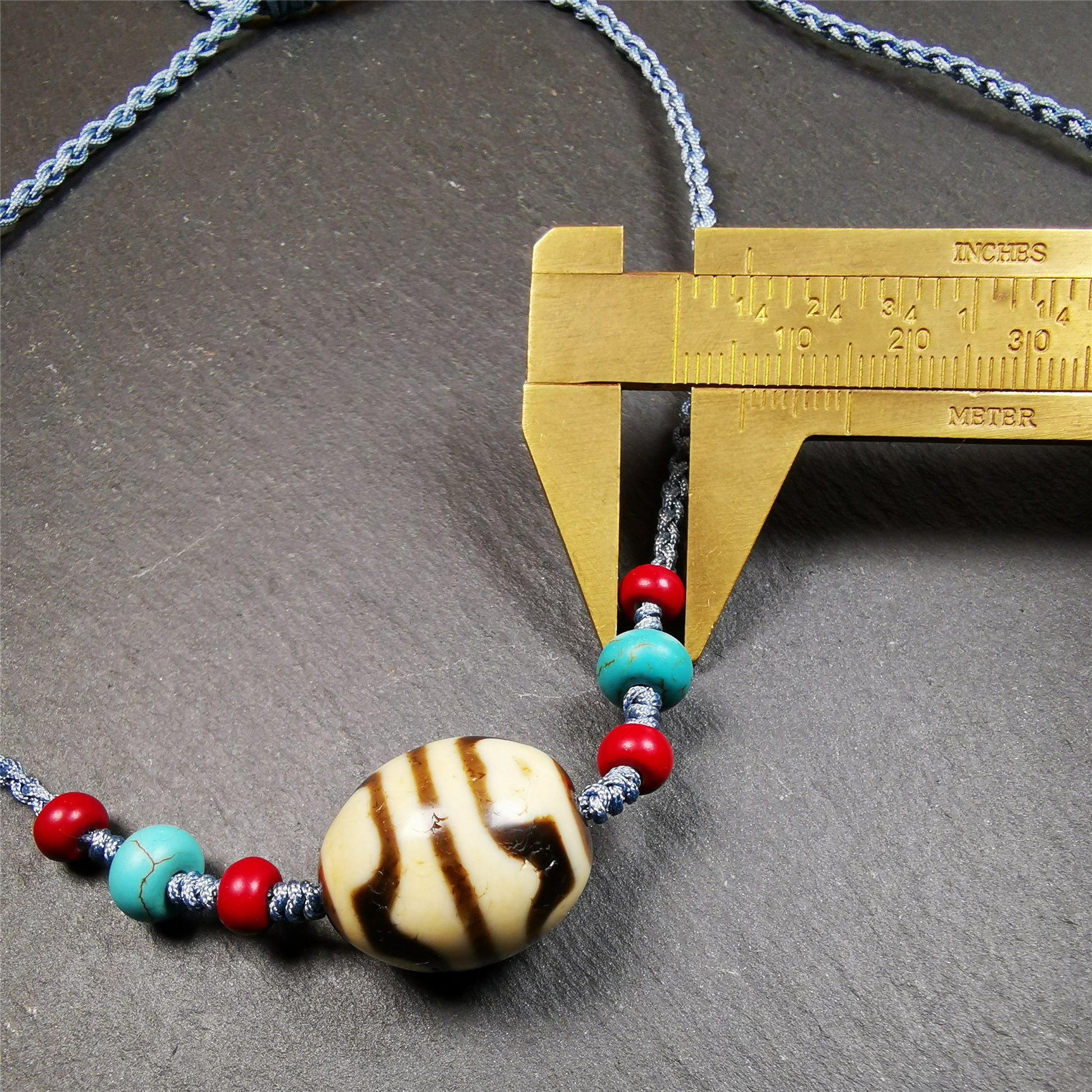 This necklace was hand-woven by Tibetans from Baiyu County, the main bead is a lotus dalo dzi bead, paired with turquoise and agate beads,about 40 years old. It can be worn not only as a fashionable accessory but also holds cultural and religious significance. The length of the necklace can be adjusted, the maximum circumference is about 60cm.