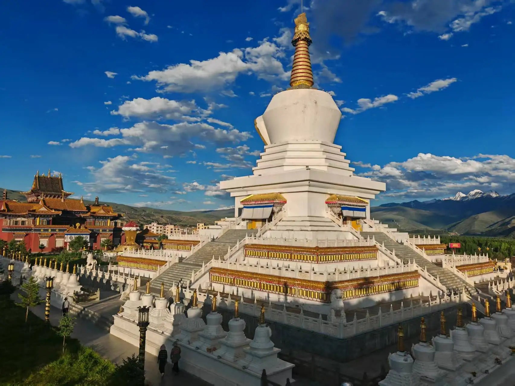 Majestic white stupa of Nacang Monastery under blue sky with snow-capped mountains in Gerze Tibet,Sichuan.