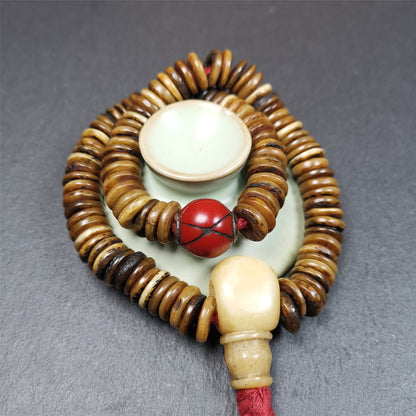 This bone carved mala beads is made by Tibetan craftsmen,about 30 years Old. It has 108 flat shape beads,1 red plastic spacer bead,and 1 yak bone guru bead,all hand carved,diameter is 12mm and perimeter is 15".