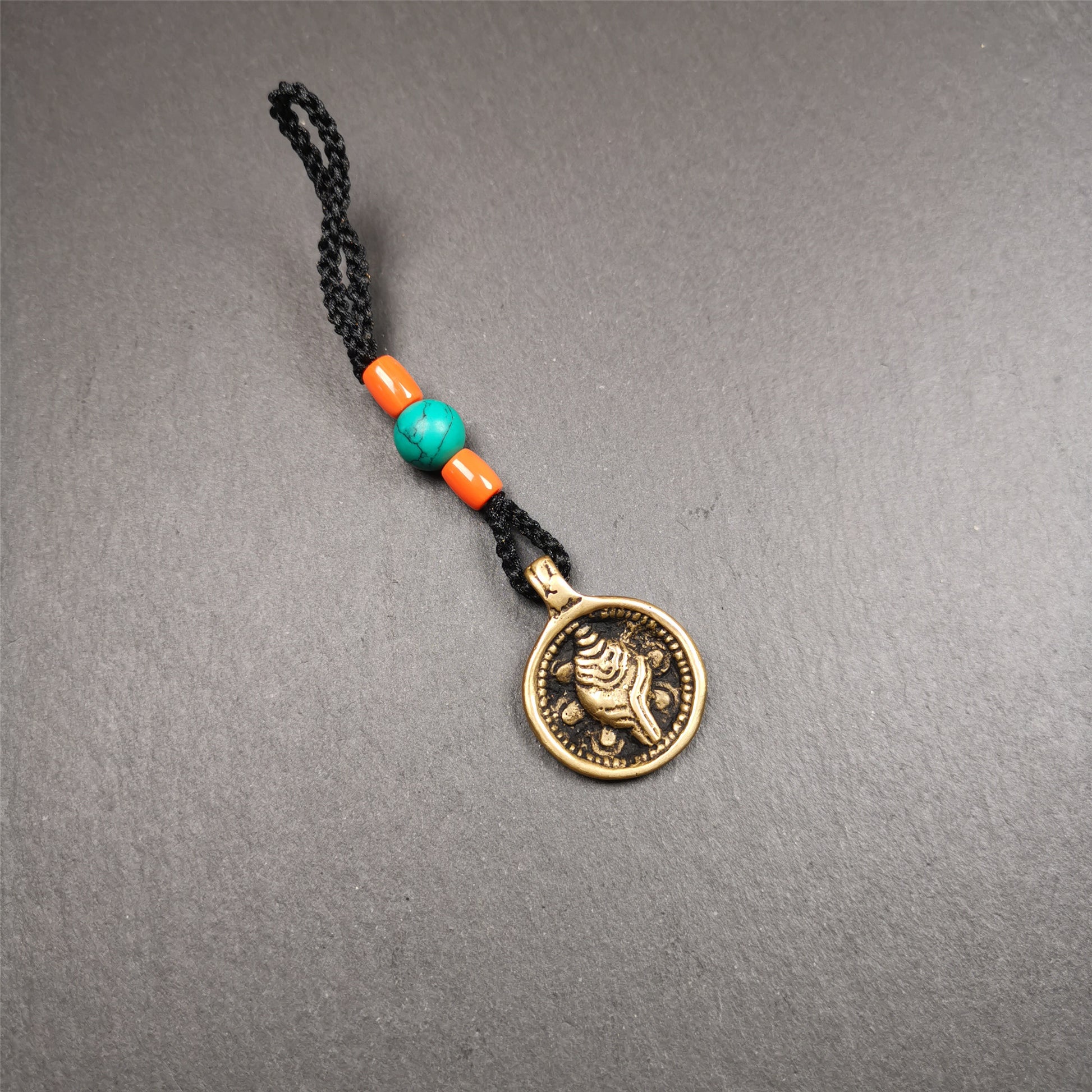 This conch amulet is made by Tibetan craftsmen in Hepo Township, Baiyu County. It is round shape,conch pattern,handwaved with small beads. You can make it into a keychain or bag hanging.