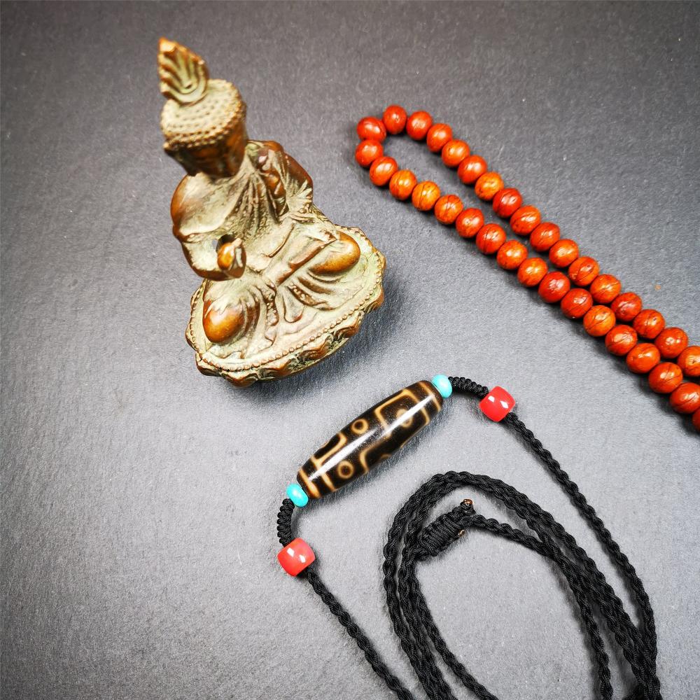 This 9 eyes dzi bead was collected from gerze Tibet,about 50 years old. The necklace was hand-woven by Tibetans from Baiyu County, the main bead is a brown color 9 eyes dzi, paired with 2 turquoise beads and 2 red agate beads.