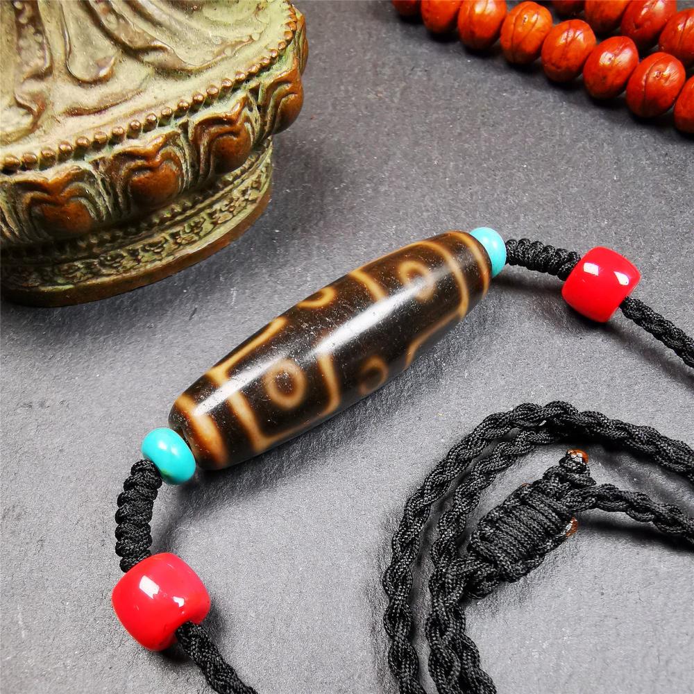 This 9 eyes dzi bead was collected from gerze Tibet,about 50 years old. The necklace was hand-woven by Tibetans from Baiyu County, the main bead is a brown color 9 eyes dzi, paired with 2 turquoise beads and 2 red agate beads.