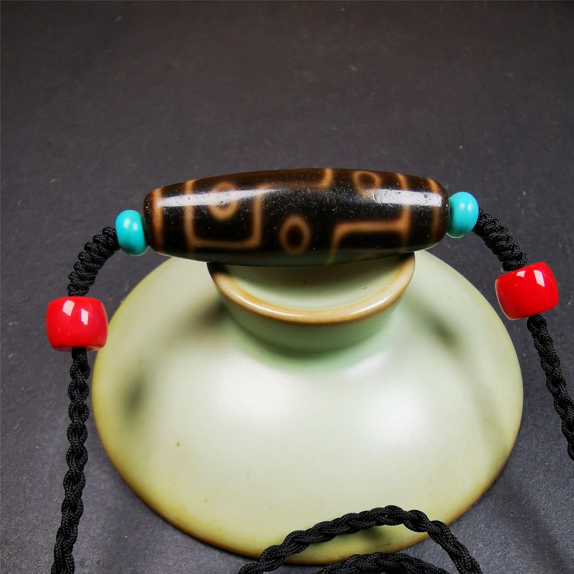This 9 eyes dzi bead was collected from gerze Tibet,about 50 years old. The necklace was hand-woven by Tibetans from Baiyu County, the main bead is a brown color 9 eyes dzi, paired with 2 turquoise beads and 2 red agate beads.