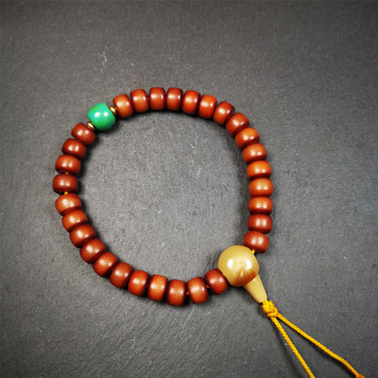 This bracelet mala was made by Tibetan craftsmen and come from Hepo Town, Baiyu County, the birthplace of the famous Tibetan handicrafts.  It is made of Corypha Linn Seeds, diameter of 10mm / 0.4",circumference is 26cm / 10" ,with turquoise spacer bead, end of a yak horn guru bead.