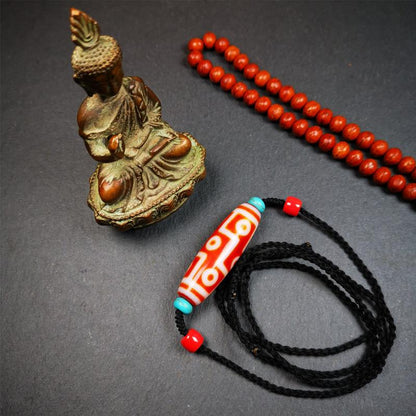 This necklace was hand-woven by Tibetans from Baiyu County, the main bead is a fire agate 9 eyes dzi, paired with 2 turquoise beads and 2 red agate beads,about 30 years old. The length of the necklace can be adjusted.