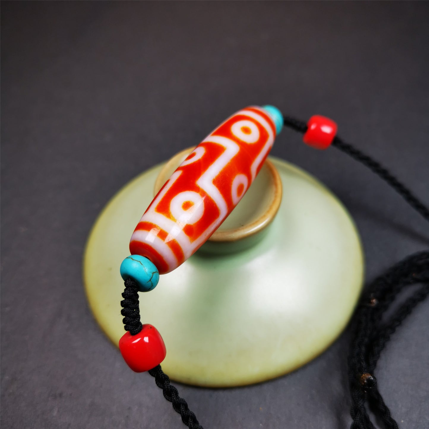 This necklace was hand-woven by Tibetans from Baiyu County, the main bead is a fire agate 9 eyes dzi, paired with 2 turquoise beads and 2 red agate beads,about 30 years old. The length of the necklace can be adjusted.