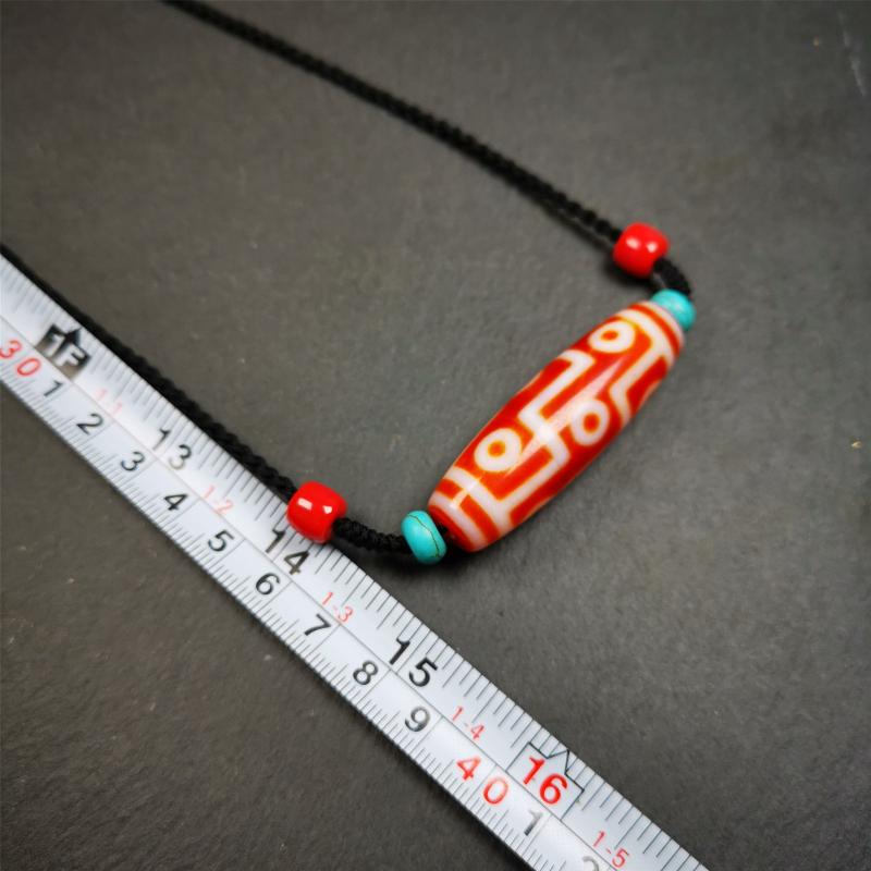 This necklace was hand-woven by Tibetans from Baiyu County, the main bead is a fire agate 9 eyes dzi, paired with 2 turquoise beads and 2 red agate beads,about 30 years old. The length of the necklace can be adjusted.