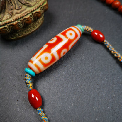 This necklace was hand-woven by Tibetans from Baiyu County, the main bead is a fire agate 9 eyes dzi, paired with 2 turquoise beads and 2 red agate beads,about 30 years old. The length of the necklace can be adjusted, the maximum circumference is about 60cm.