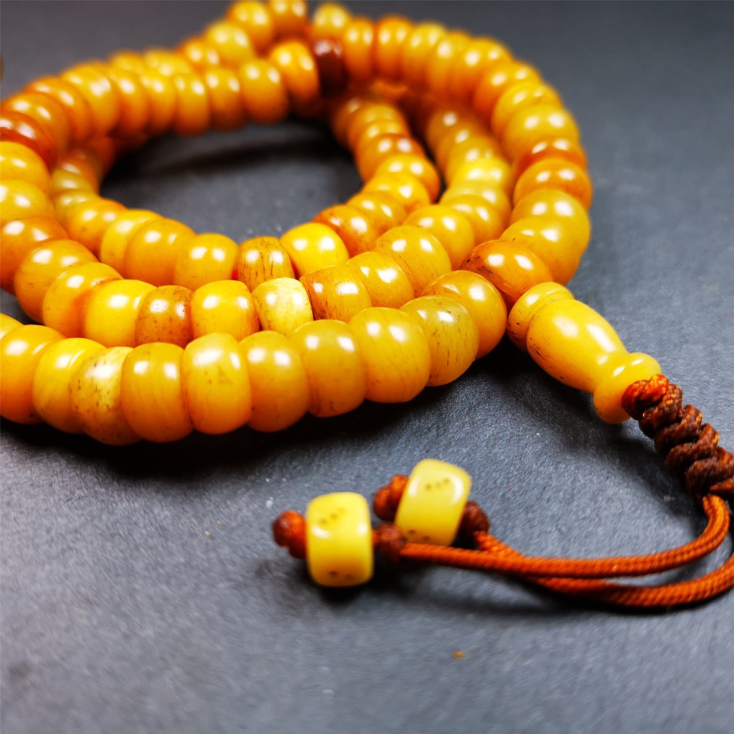 This mala was made by Tibetan craftsmen,about 20 years old. It is made of yak bone, yellow color,108 barrel cut beads diameter of 10mm / 0.4",circumference is 64cm / 25.2",1 guru bead and 2 dice pendant beads.