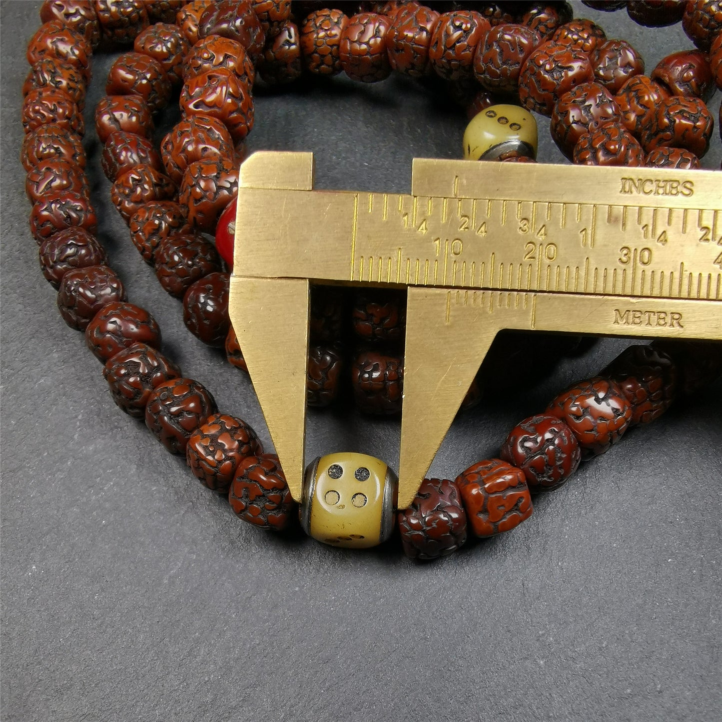 This old mala was handmade from tibetan crafts man in Baiyu County,blessed in Baiyu monastery. It's composed of 108 pcs 9mm rudraksha beads,with 3 carved dice beads,bead diameter is 0.35 inch and circumference is 35 inches.