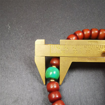 This bracelet mala was made by Tibetan craftsmen and come from Hepo Town, Baiyu County, the birthplace of the famous Tibetan handicrafts.  It is made of Corypha Linn Seeds, diameter of 10mm / 0.4",circumference is 26cm / 10" ,with turquoise spacer bead, end of a yak horn guru bead.