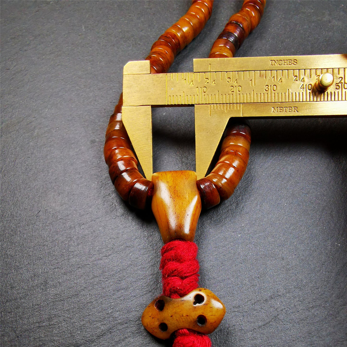 This mala was made by Tibetan craftsmen,about 30 years old.  It is made of yak bone, brown color,108 beads diameter of 8.5mm / 0.34",circumference is 48cm / 18.9",include 3 spacer beads, 1 guru bead,and 1 bone vajra pendant.