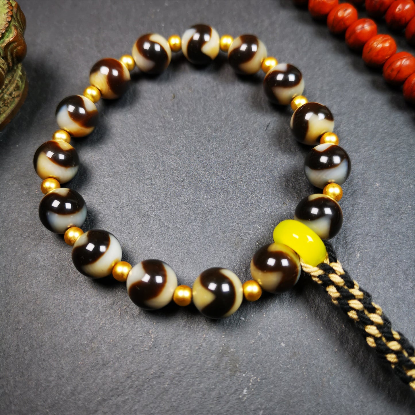 This tiger tooth dzi bracelet was hand-woven by Tibetans from Baiyu County,Tibet. It consists of 15 tiger tooth dzi beads and 15 spacer beads,tie with elastic cord to fit your wrist.  Dzi beads are precious jewelry from Tibetan culture which are believed to possess the power of bringing good fortune to the owners.  You'll get 1 dzi bracelet as pictures shown.