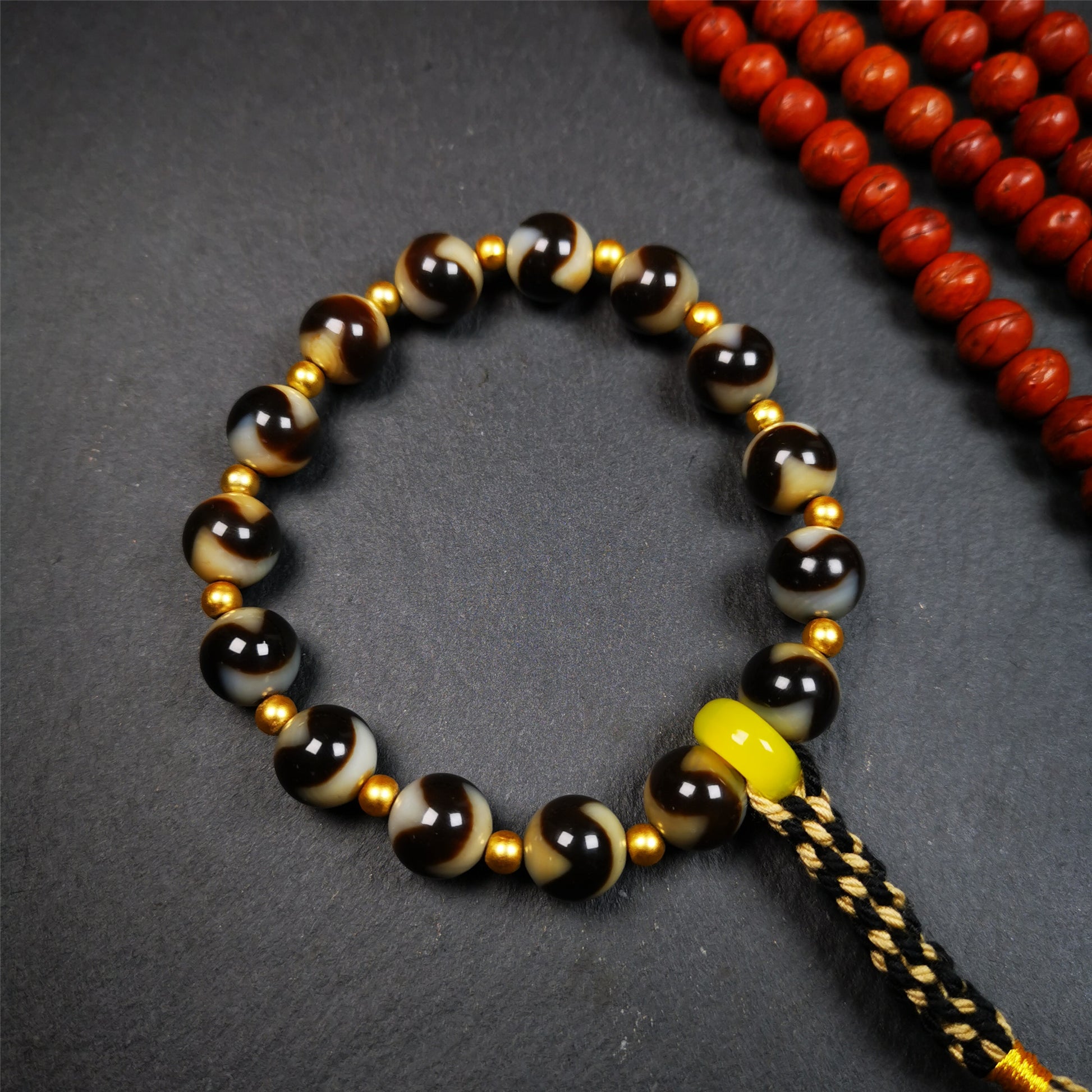 This tiger tooth dzi bracelet was hand-woven by Tibetans from Baiyu County,Tibet. It consists of 15 tiger tooth dzi beads and 15 spacer beads,tie with elastic cord to fit your wrist.  Dzi beads are precious jewelry from Tibetan culture which are believed to possess the power of bringing good fortune to the owners.  You'll get 1 dzi bracelet as pictures shown.