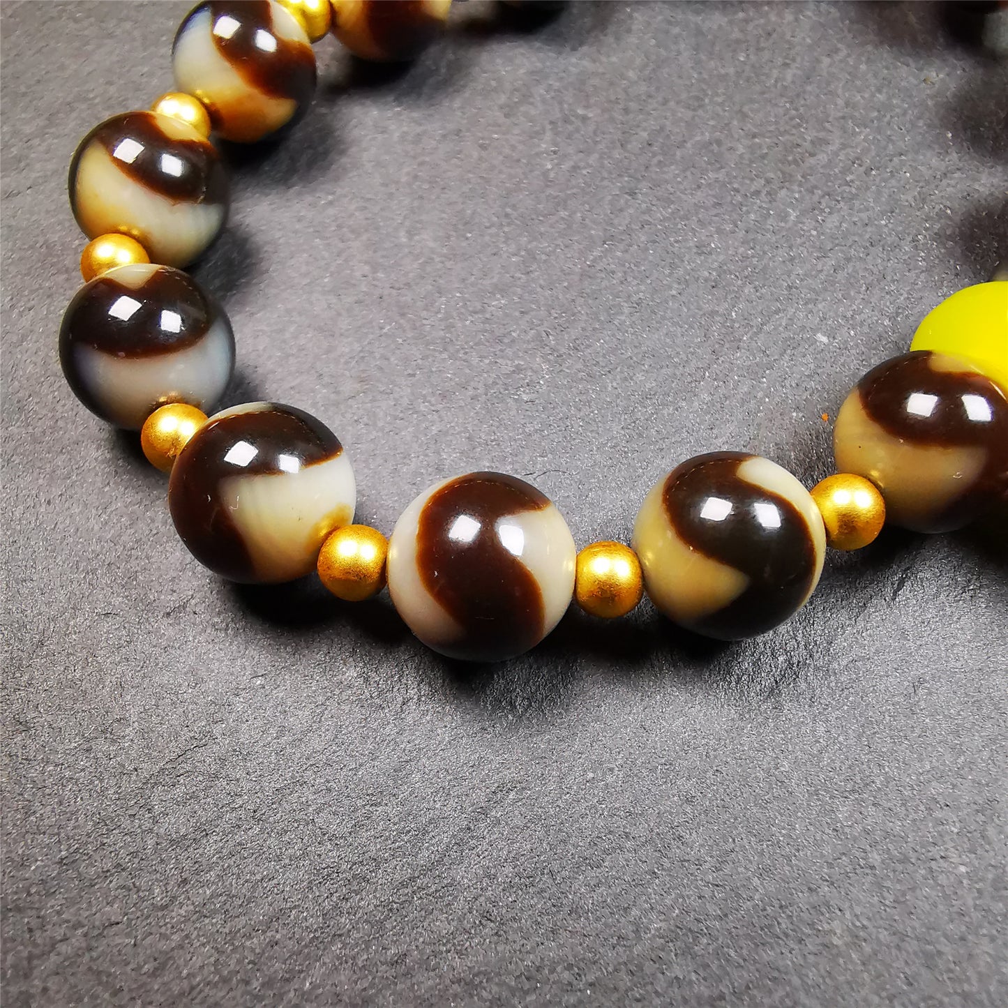 This tiger tooth dzi bracelet was hand-woven by Tibetans from Baiyu County,Tibet. It consists of 15 tiger tooth dzi beads and 15 spacer beads,tie with elastic cord to fit your wrist.  Dzi beads are precious jewelry from Tibetan culture which are believed to possess the power of bringing good fortune to the owners.  You'll get 1 dzi bracelet as pictures shown.