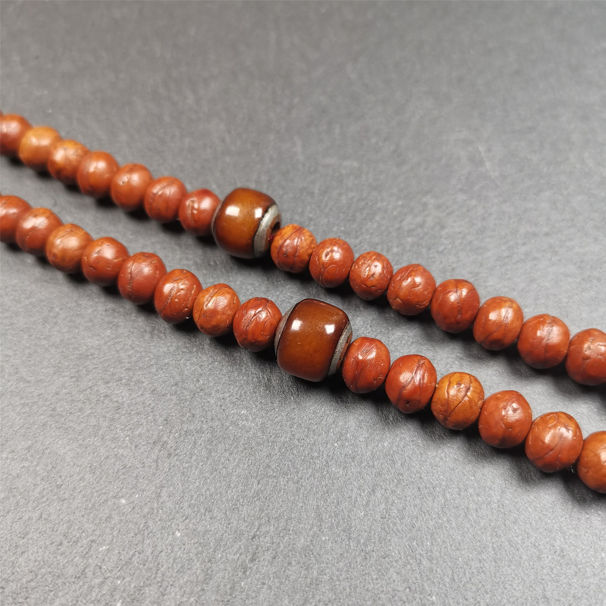 These marker beads were handmade by Tibetan craftsmen and come from Hepo Town, Baiyu County, the birthplace of the famous Tibetan handicrafts. It is made of yak bone,inlaid cold iron,brown color,size is 0.47" × 0.4". Fit for 8-12mm mala (The reference in the photo is 9mm mala)