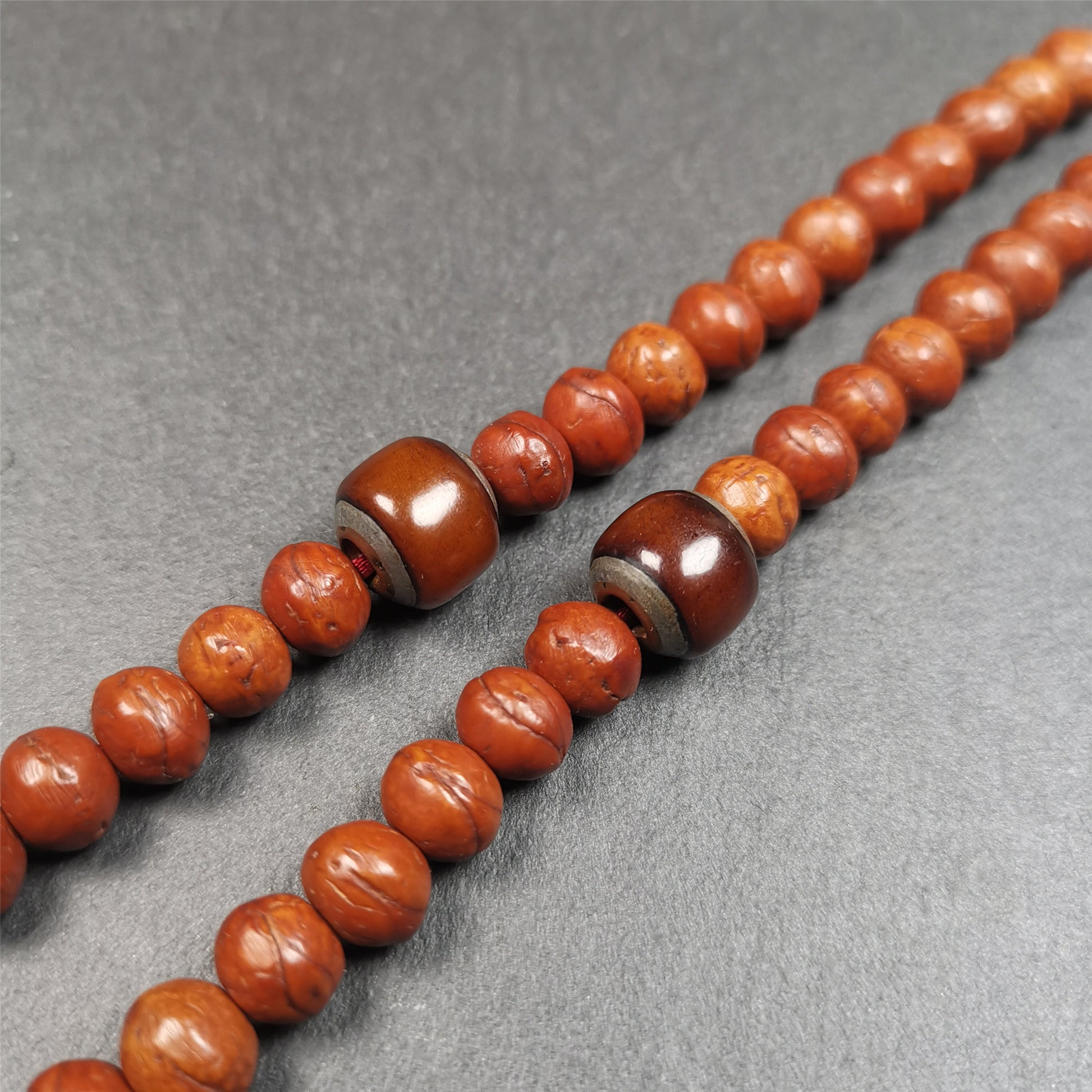 These marker beads were handmade by Tibetan craftsmen and come from Hepo Town, Baiyu County, the birthplace of the famous Tibetan handicrafts. It is made of yak bone,inlaid cold iron,brown color,size is 0.47" × 0.4". Fit for 8-12mm mala (The reference in the photo is 9mm mala)