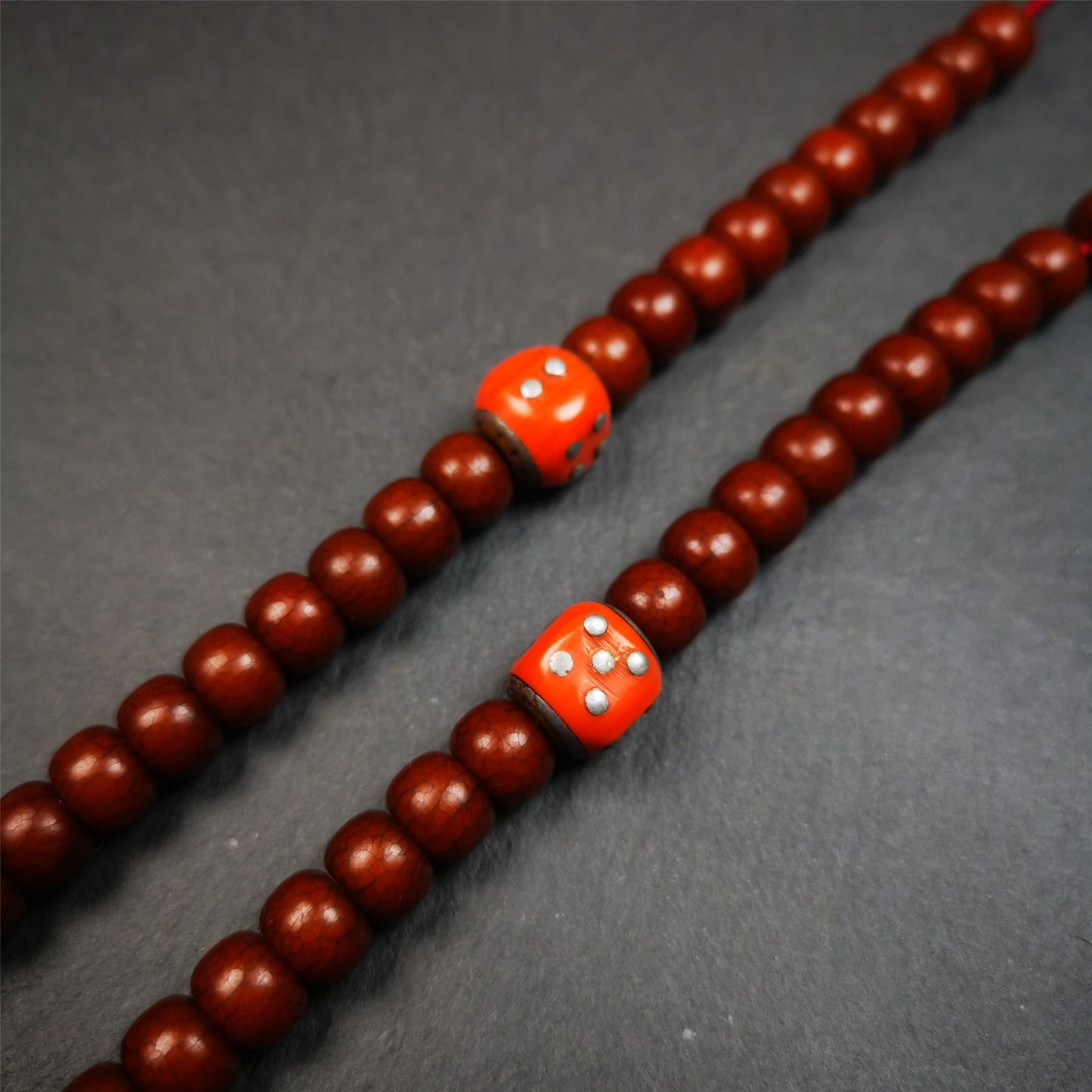 These marker beads were handmade by Tibetan craftsmen and come from Hepo Town, Baiyu County, the birthplace of the famous Tibetan handicrafts. It is made of plastic,inlaid cold iron,orange color,size is 0.47" × 0.47". Fit for 8-12mm mala (The reference in the photo is 8mm mala)