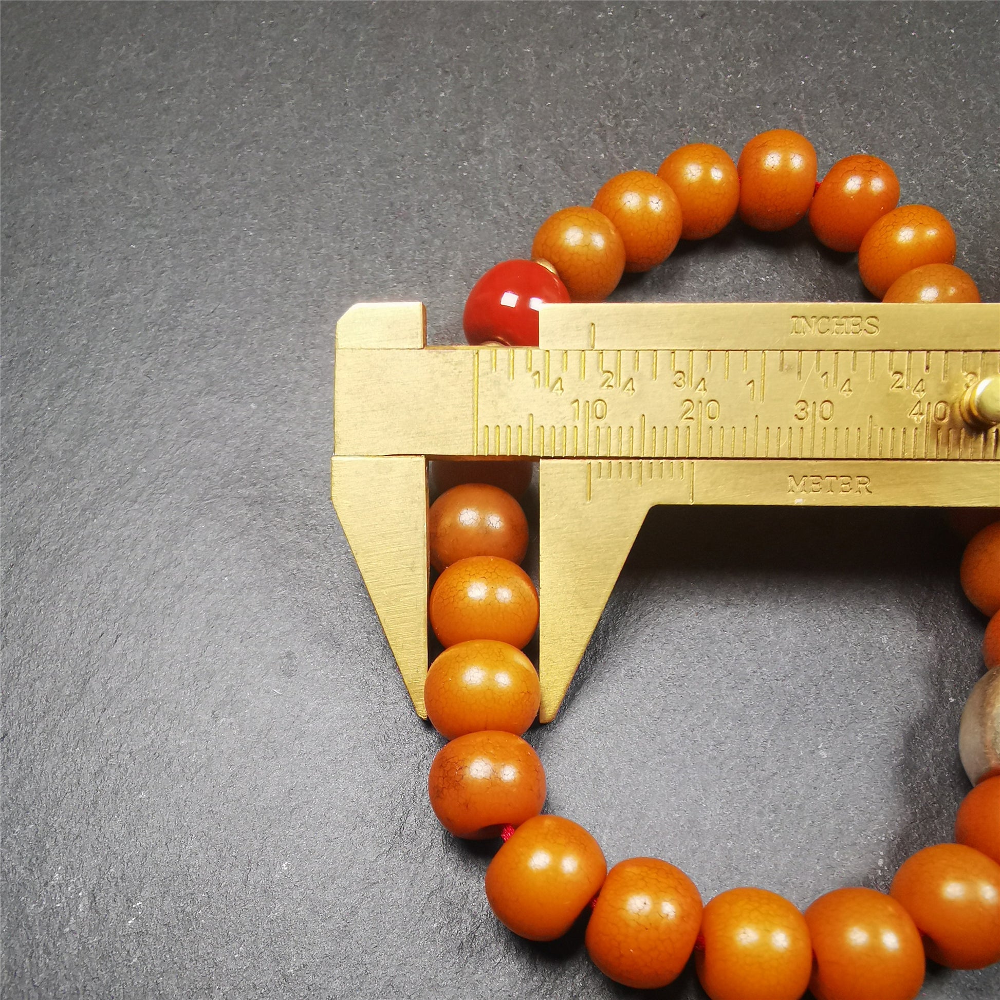 This mala was made by Tibetan craftsmen.  It is made of Corypha Linn Seeds, diameter of 10mm / 0.4",circumference is 22cm / 8.7" ,with agate spacer bead, end of a white copper guru bead.