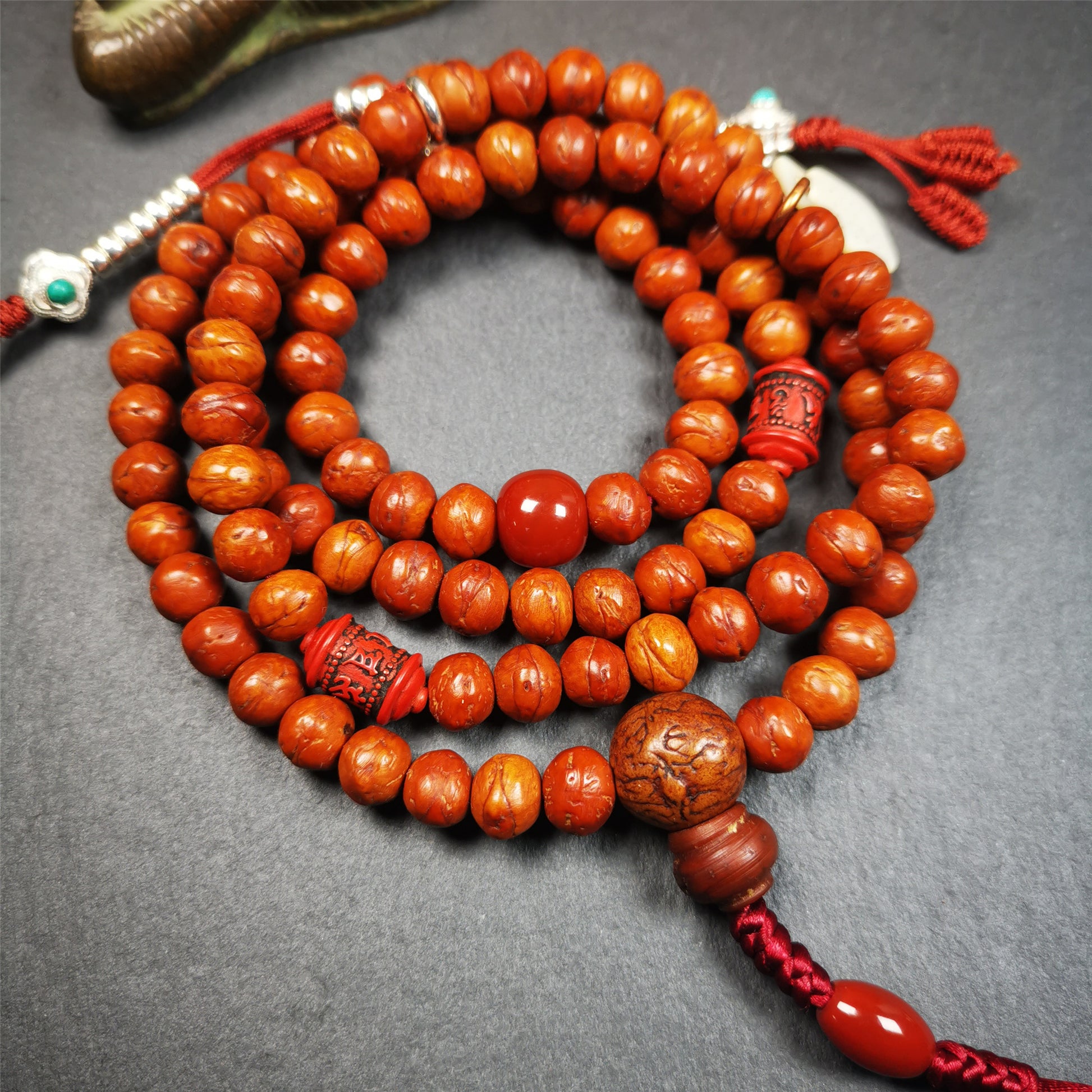 This bodhi beads mala is made by Tibetan craftsmen,about 30 years old.  It is composed of 108 bodhi seed beads, equipped with agate beads, cinnabar beads,silver bead counters are installed on both sides, 1 mantra dot clip,and finally consists a guru bead and agate bead on the end, very elegant.