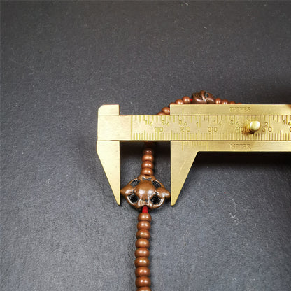 This mala was collect from Hepo Town Baiyu County Tibet, blessed in Yaqing Monastry. It is made of copper,brown color,length is 44cm / 18",has 1 Kartika ,2 skeletons, 2 stamp pendant, and 2 strings of counters with phurba + kartika.