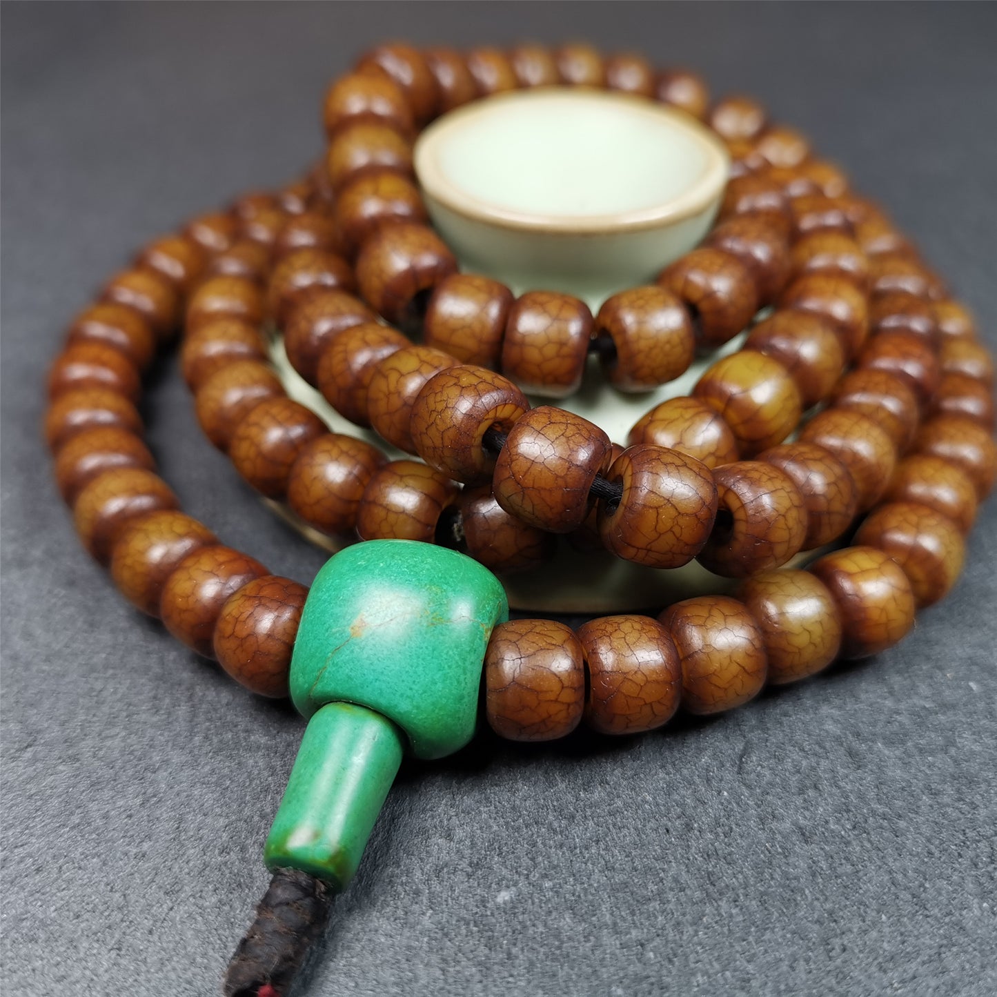 This mala was made by Tibetan craftsmen.  It is made of Corypha Linn Seeds, diameter of 10mm,0.4 inch,circumference is 80cm,32 inches , end of a turquoise guru bead.