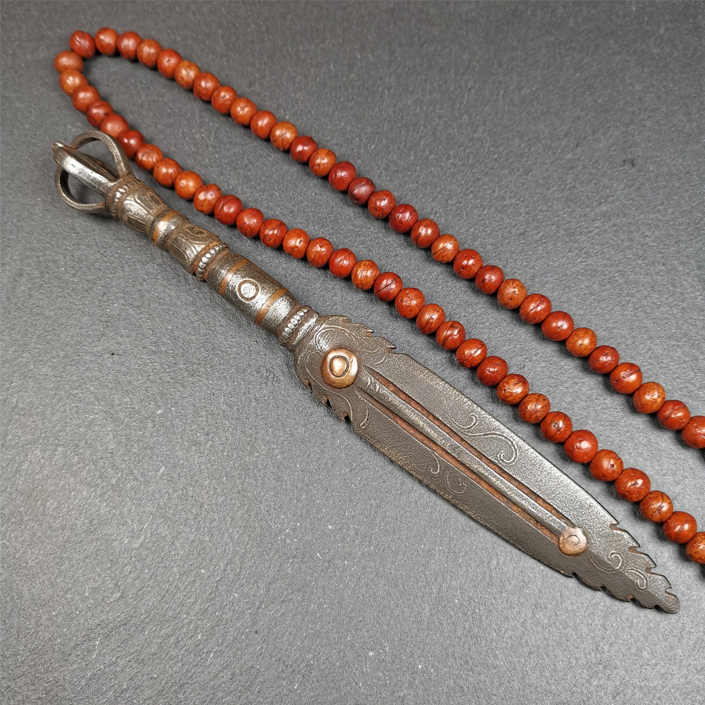 This vajra sword was handmade by Tibetan craftsmen from Tibet in 1990s. It's Fire Vajra Sword of Wisdom Buddha Manjushri,made of cold iron,inlaid red copper stripe,carved with flame pattern, and the half vajra at the tail,7.5 inches length.
