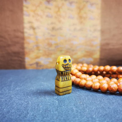 This skull seal amulet was made by Tibetan craftsmen and come from Hepo Town, Baiyu County, the birthplace of the famous Tibetan handicrafts. It's made of yak bone,yellow color,carved skull shape,and OM letter at the bottom,height is  inches. You can make it a pendant, keychain.