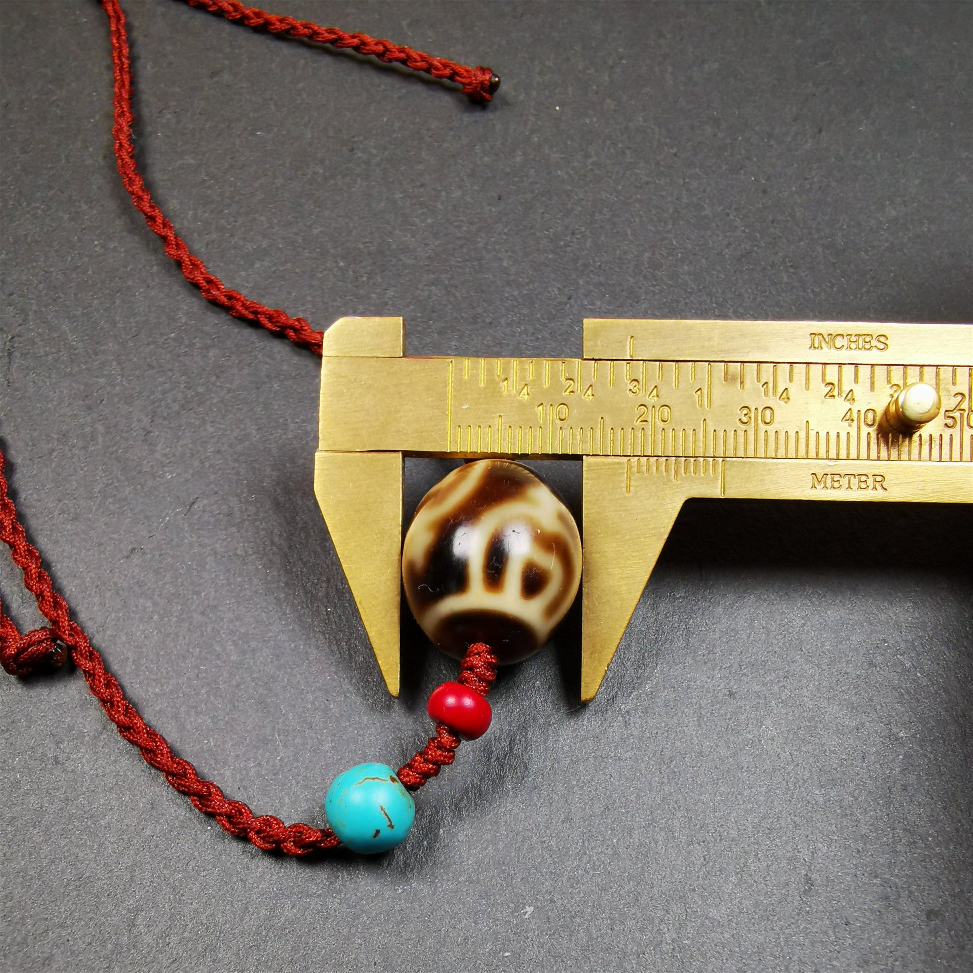 This necklace was hand-woven by Tibetans from Baiyu County, the main bead is a treasure vase dalo dzi, paired with 2 turquoise and 2 sharpa beads,about 30 years old. It can be worn as a fashionable accessory,holds cultural and religious significance.