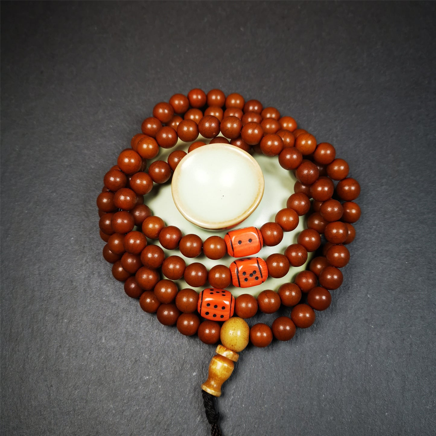 This mala was made by Tibetan craftsmen and come from Hepo Town, Baiyu County, the birthplace of the famous Tibetan handicrafts.  It is made of Corypha Linn Seeds, diameter of 8mm / 0.32",circumference is 90cm / 35" ,with 3 dice bead, end of a yak bone guru bead.