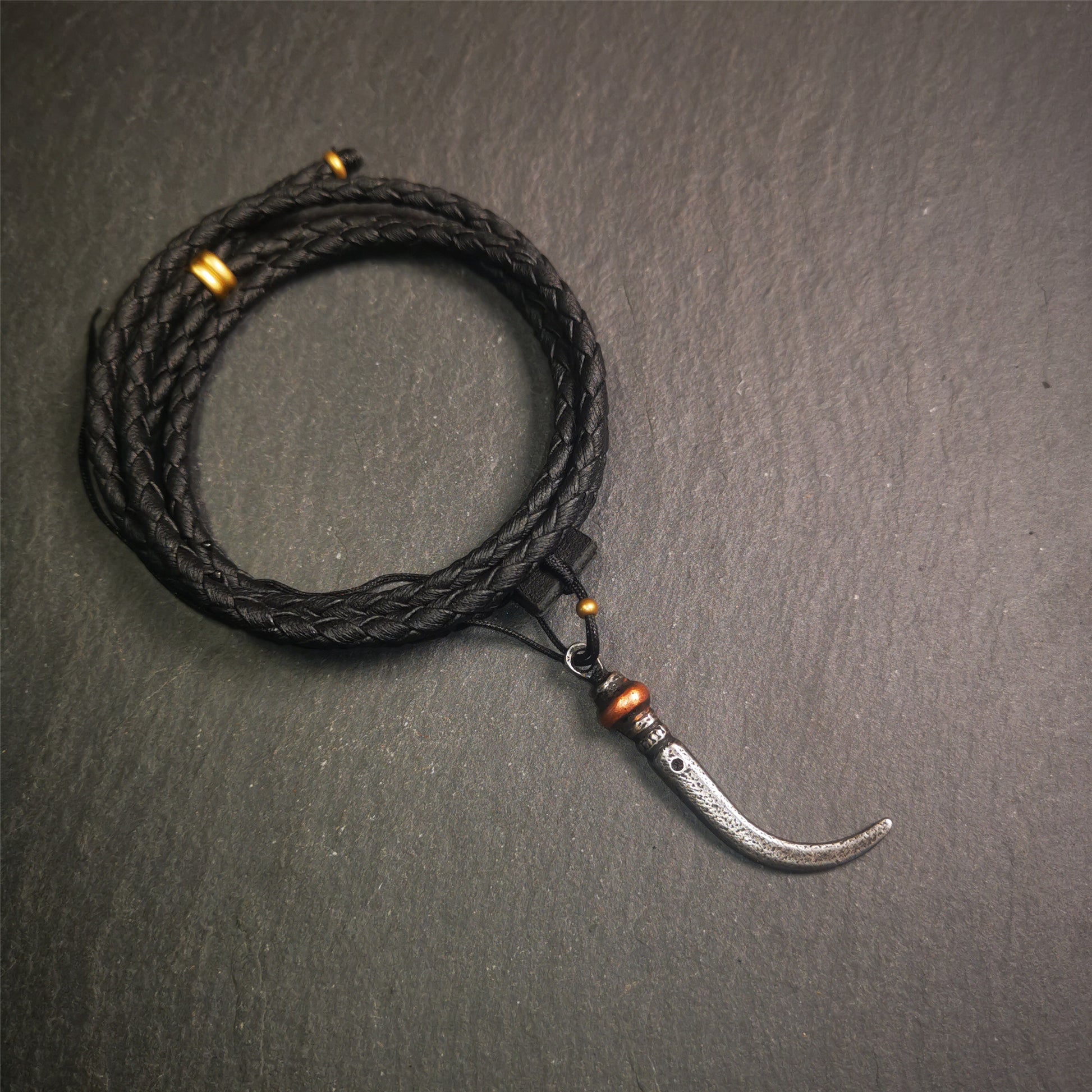 This wolf tooth pendant is made by Tibetan craftsmen and come from Hepo Town, Baiyu County, the birthplace of the famous Tibetan handicrafts. It's made of cold iron and inlaid copper,the body is black color,length is 1.77 inches. You can make it a necklace or mala pendant, or keychain.