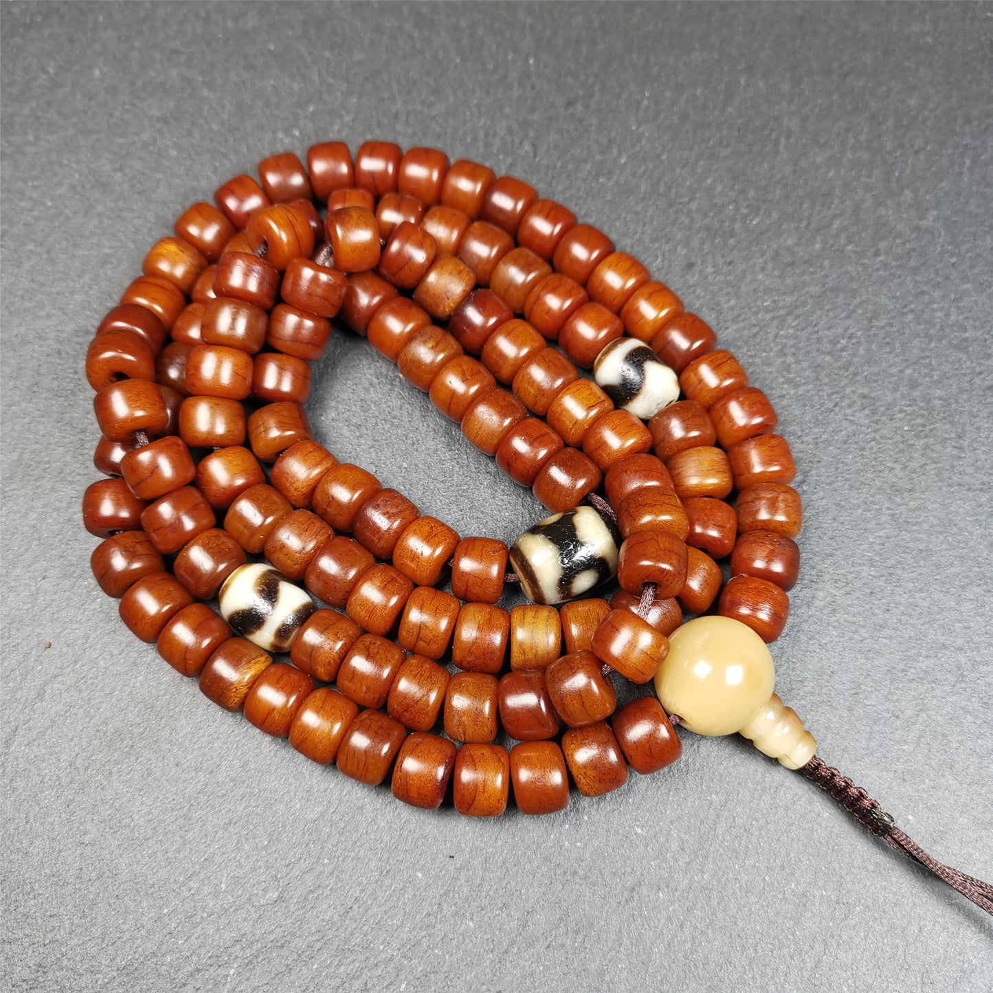 This mala was made by Tibetan craftsmen and come from Hepo Town.  It is made of yak bone, brown color,108 dice beads diameter of 10mm,0.4",circumference is 84cm,33",and 3 dzi beads,end of a yak horn guru bead.