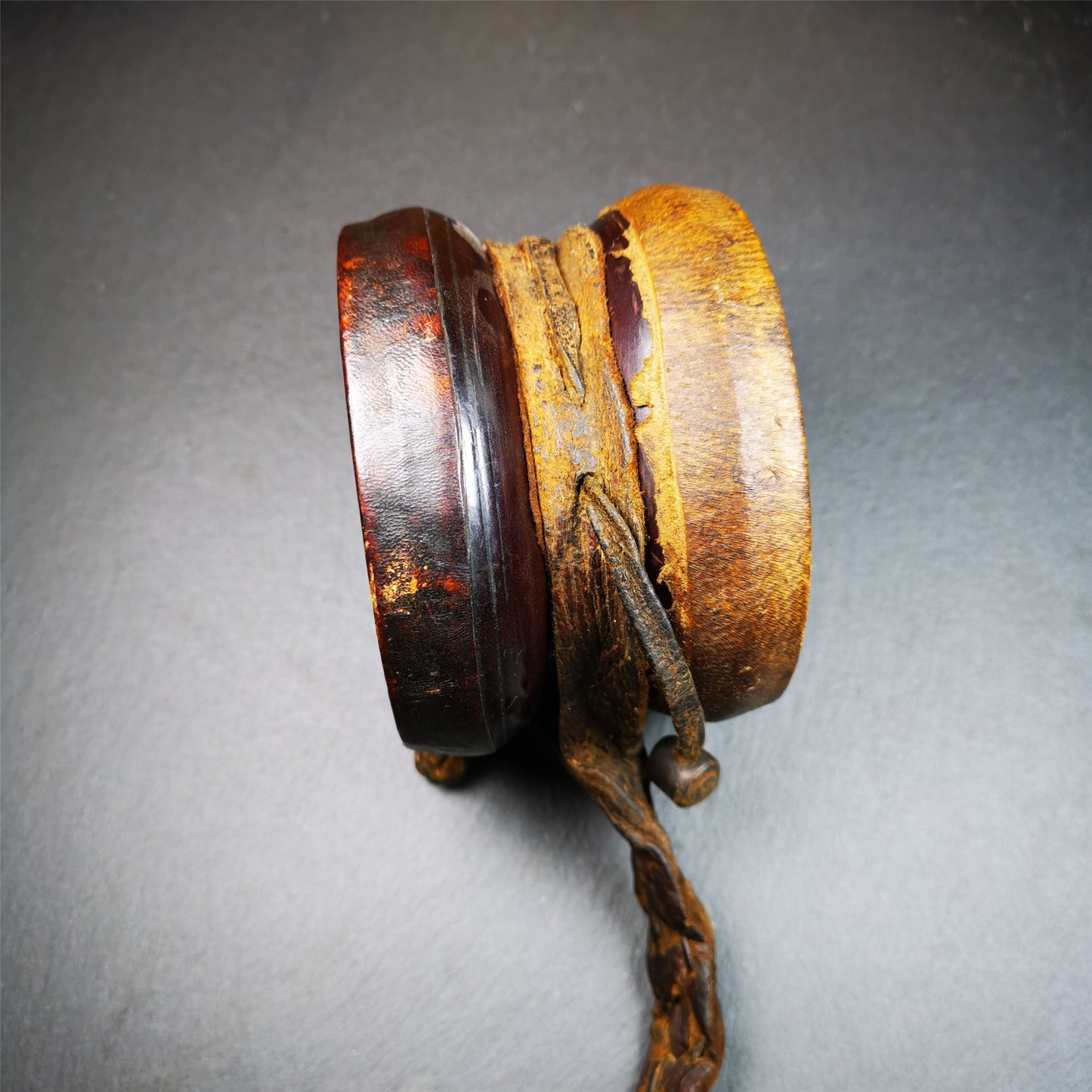 This Old Damaru Chod Drum was collected from a vallage in Gerze Tibet,about 60 years old,used and blessed by lama. It is made of Wood,Sheepskin and leather cord,the drumsticks are also made of leather cords, the drum skin shows different colors because one side of it was damaged and repaired long time ago.