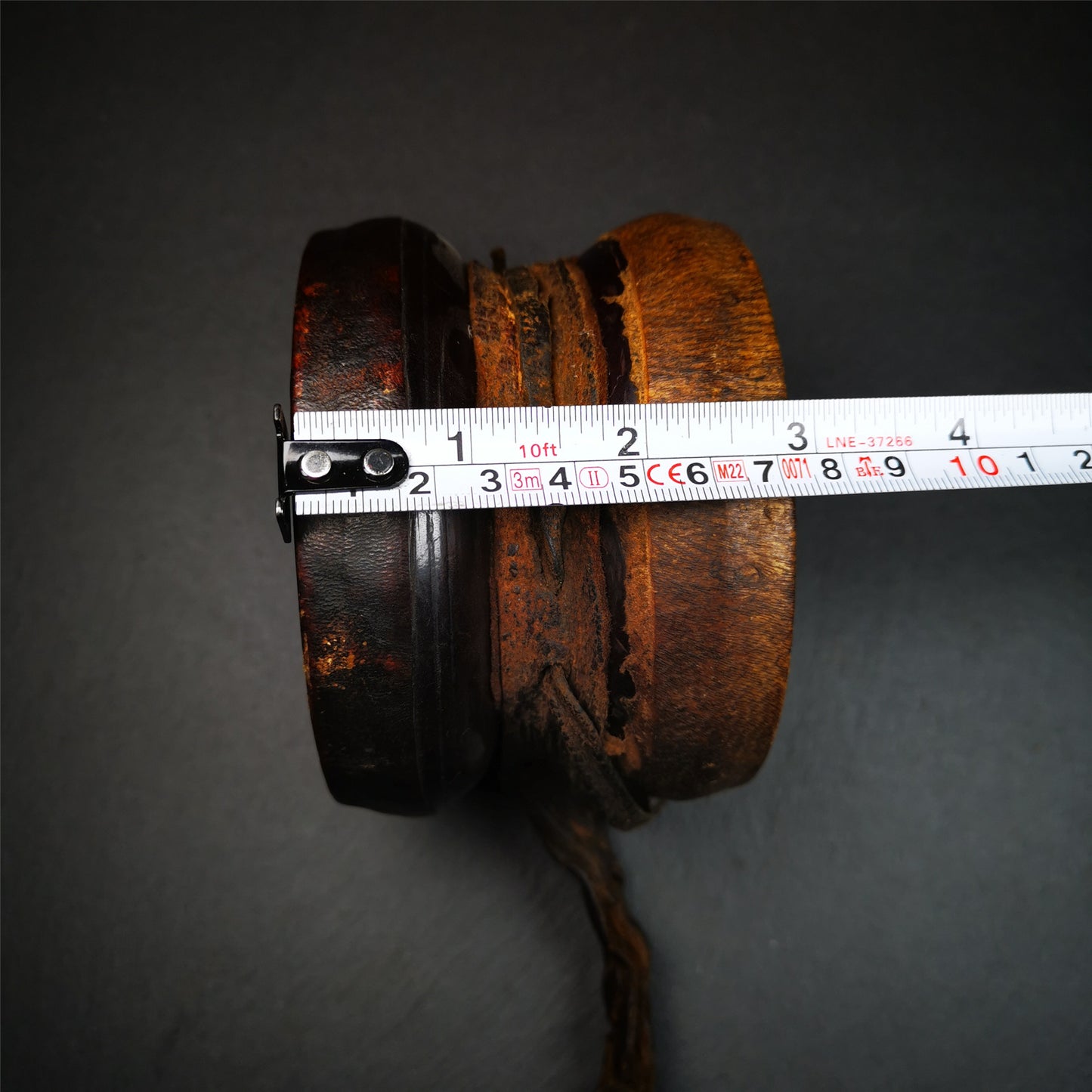 This Old Damaru Chod Drum was collected from a vallage in Gerze Tibet,about 60 years old,used and blessed by lama. It is made of Wood,Sheepskin and leather cord,the drumsticks are also made of leather cords, the drum skin shows different colors because one side of it was damaged and repaired long time ago.