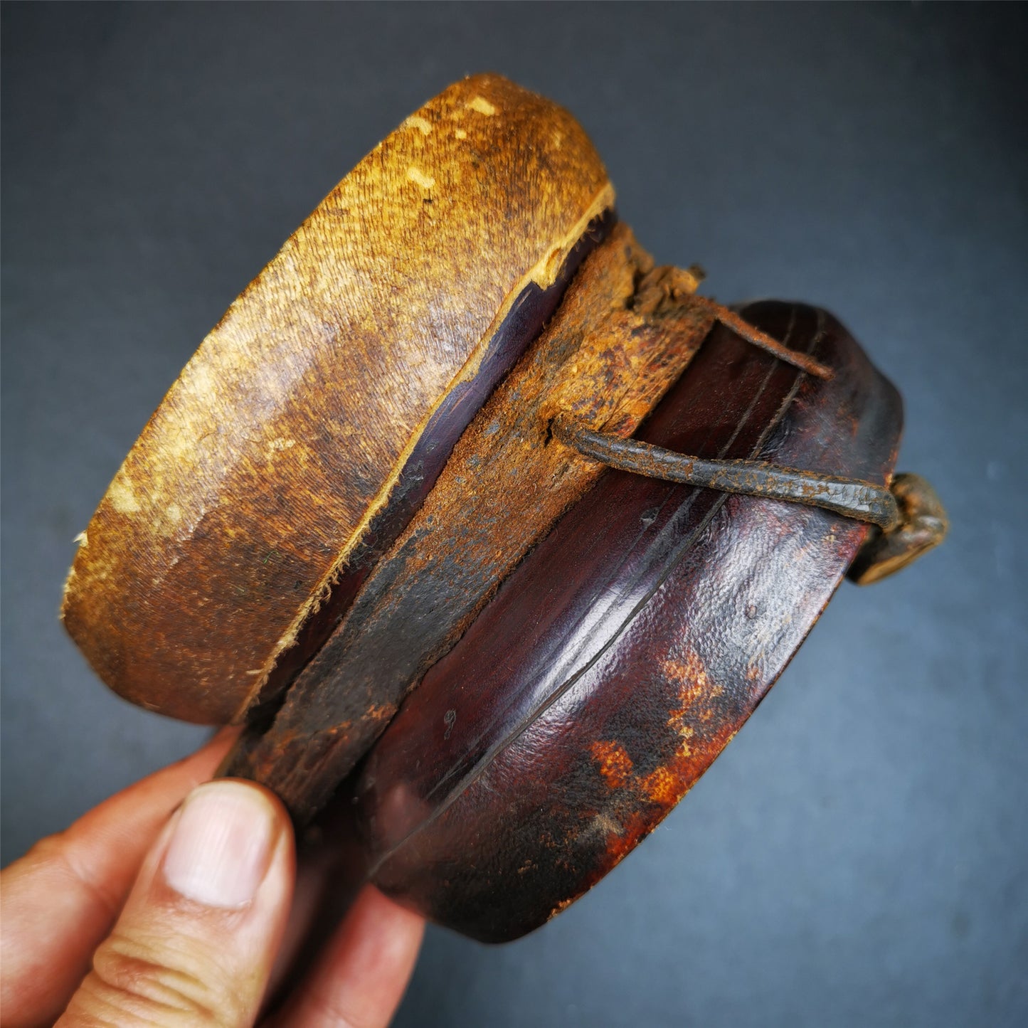 This Old Damaru Chod Drum was collected from a vallage in Gerze Tibet,about 60 years old,used and blessed by lama. It is made of Wood,Sheepskin and leather cord,the drumsticks are also made of leather cords, the drum skin shows different colors because one side of it was damaged and repaired long time ago.