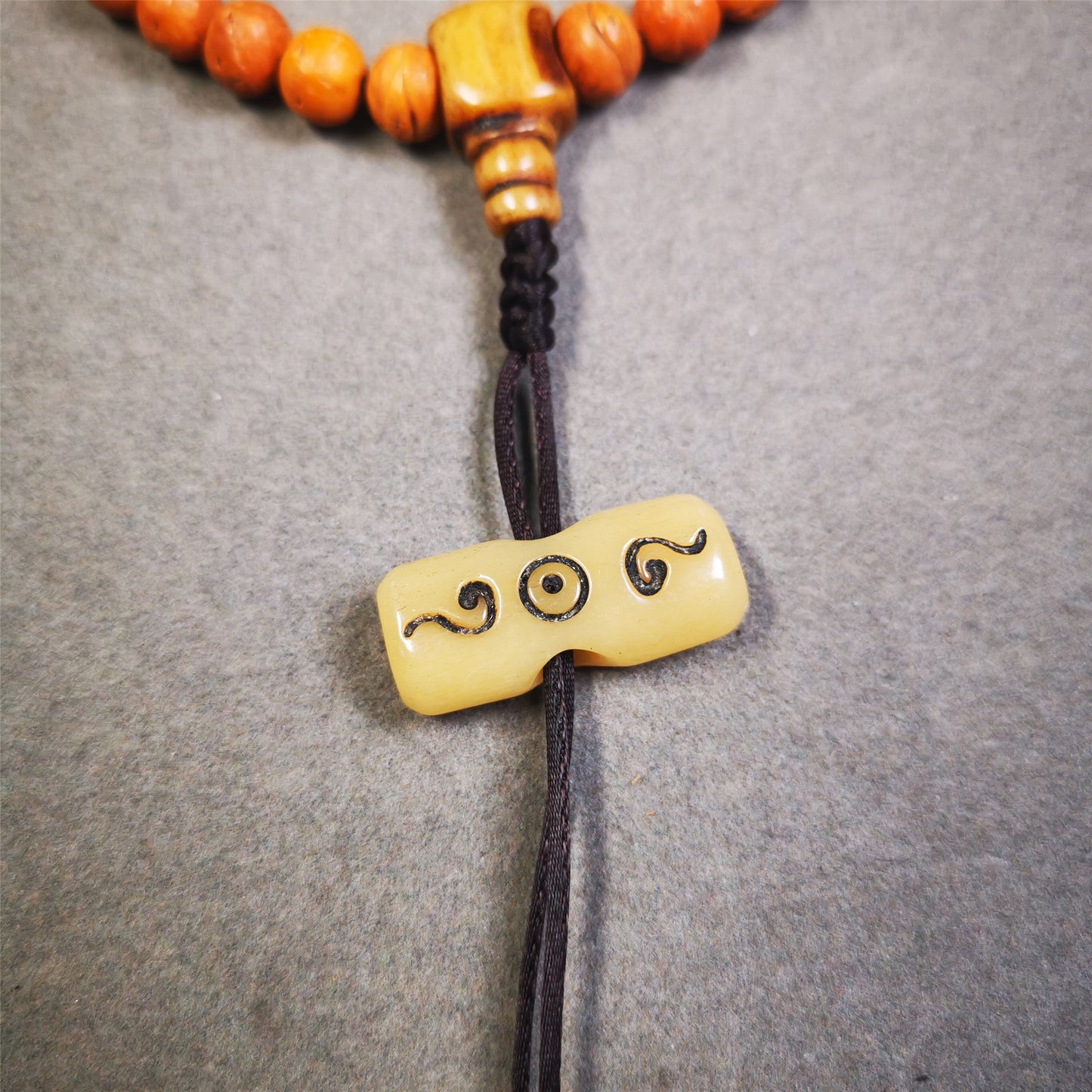 This unique bone carved ruyi pendant is made by Tibetan craftsmen in Hepo Township, Baiyu County, the birthplace of the famous Tibetan handicrafts.  You can use it as a spacer bead on mala,or pendant bead under guru bead. Also can be use as amulet pendant or keychain.