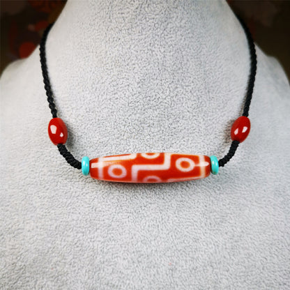 This fire agate 9 eyes dzi necklace was hand-woven by Tibetans from Baiyu County, the main bead is a fire agate 9 eyes dzi, paired with 2 turquoise beads and 2 red agate beads,about 30 years old. The length of the necklace can be adjusted, the maximum circumference is about 60cm.