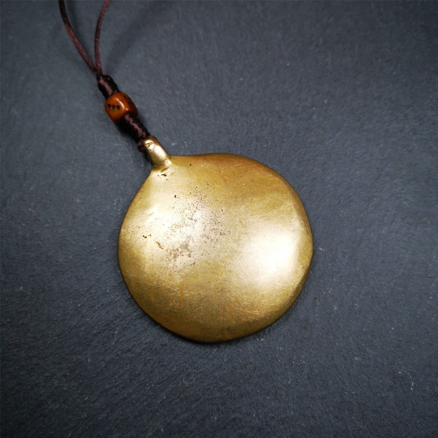 This unique tibetan melong badge was handmade by Tibetan Artist from Baiyu County. It's a Astrology Protective Amulet Pendant,made of brass,the front pattern is Tibetan Budhist Protective Amulet Pendant - SIPAHO(srid pa ho),a bone carved dice bead in the middle of the lanyard.
