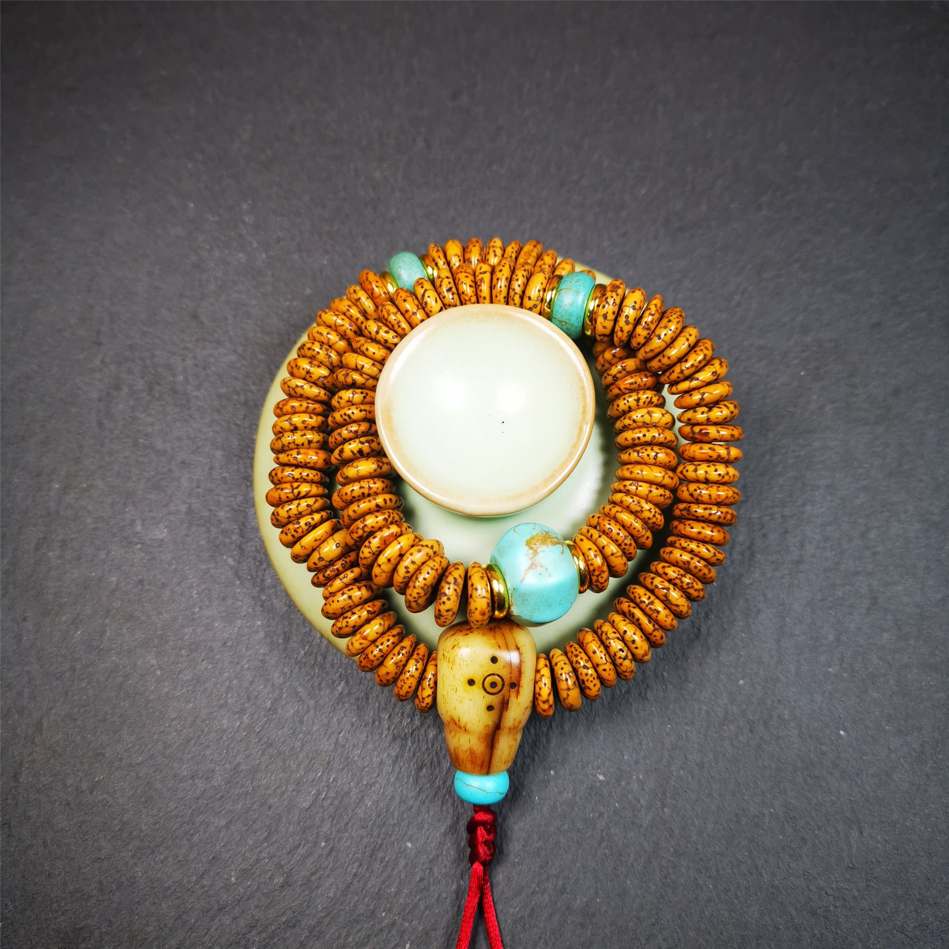 This flat lotus seed mala was collected from Gerze county,about 30 years old,hold and blessed by a lama. It is composed of 108 bodhi seed beads, flat cut shape,brown color,with 4 turquoise beads and 1 yak bone guru bead.