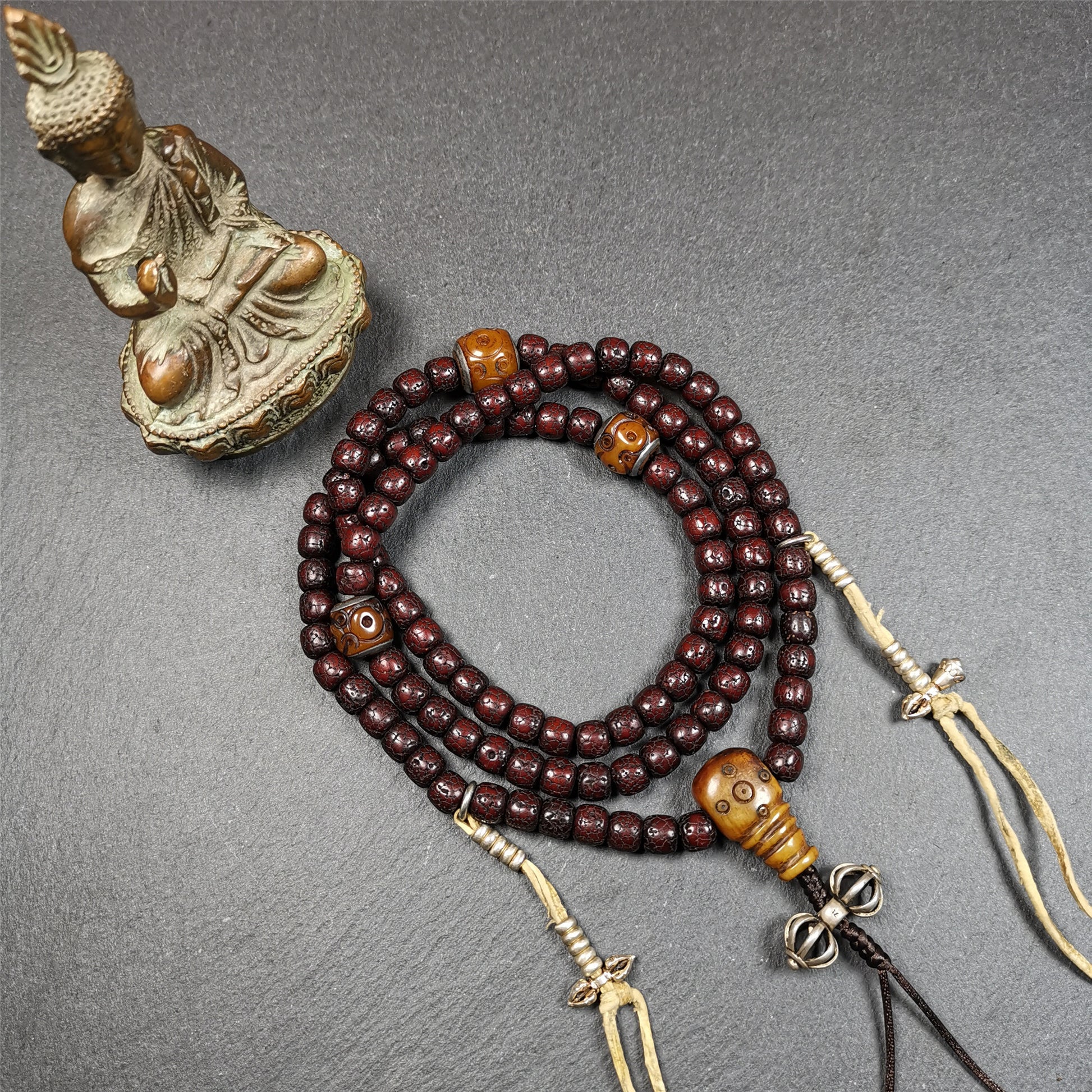 This mala is made by Tibetan craftsmen and come from Hepo Town, Baiyu County,Tibet, the birthplace of the famous Tibetan handicrafts,about 30 years old,blessed by a lama in Baiyu Monastery. It's composed of 108 pcs 8mm lotus seed beads,then add some old bone beads,1 pair of silver bead counters,and silver guru bead,vajra pandent 