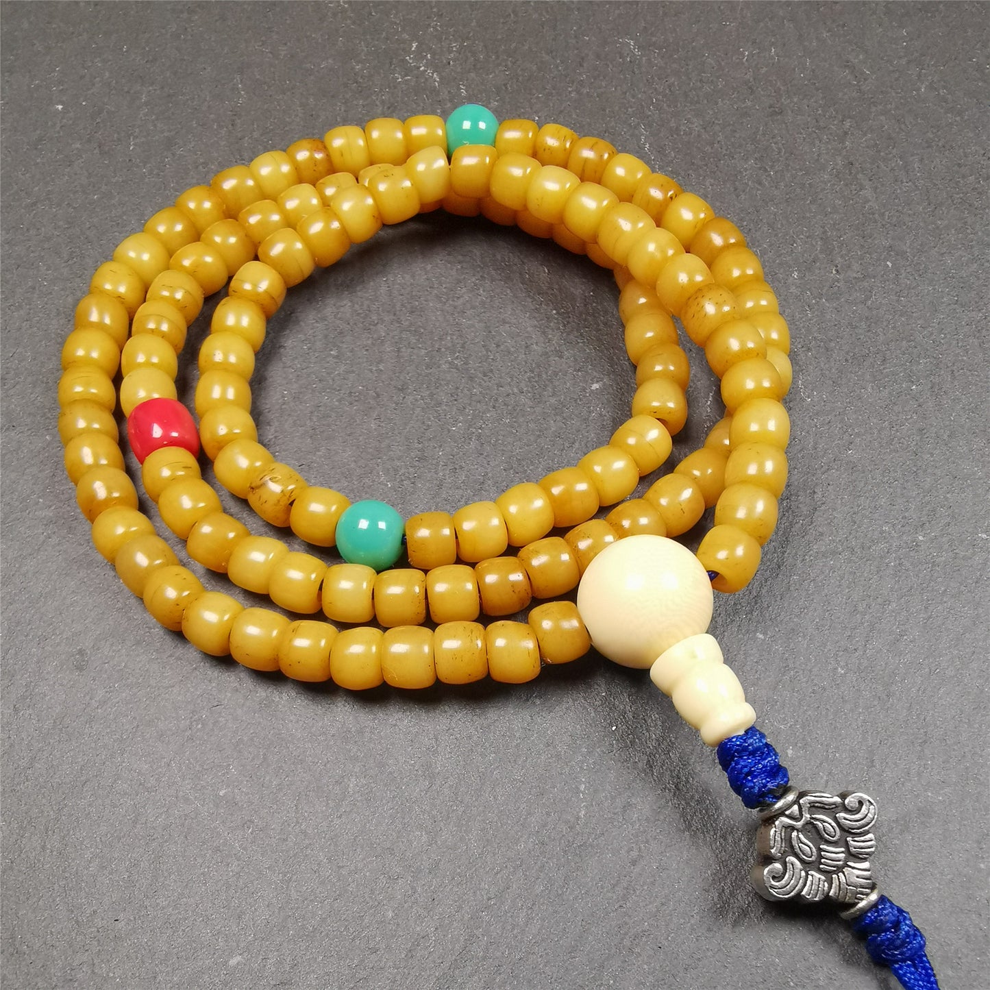 This yak bone mala was handmade from tibetan crafts man in Baiyu County. It's composed of 108 pcs 7mm bone beads,with agate and turquoise beads,guru bead,and mani jewel pendant.