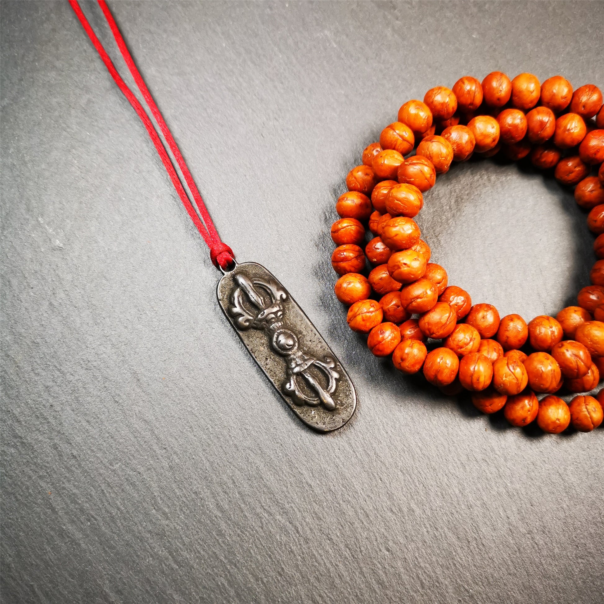 This unique Vajra pendant are collected from Yaqing Monastery,handmade of copper. It has a vajra on the front and the OM mantra of Tibetan Buddhism and the eight treasures tribute on the back. You can make them into necklace, or keychain.