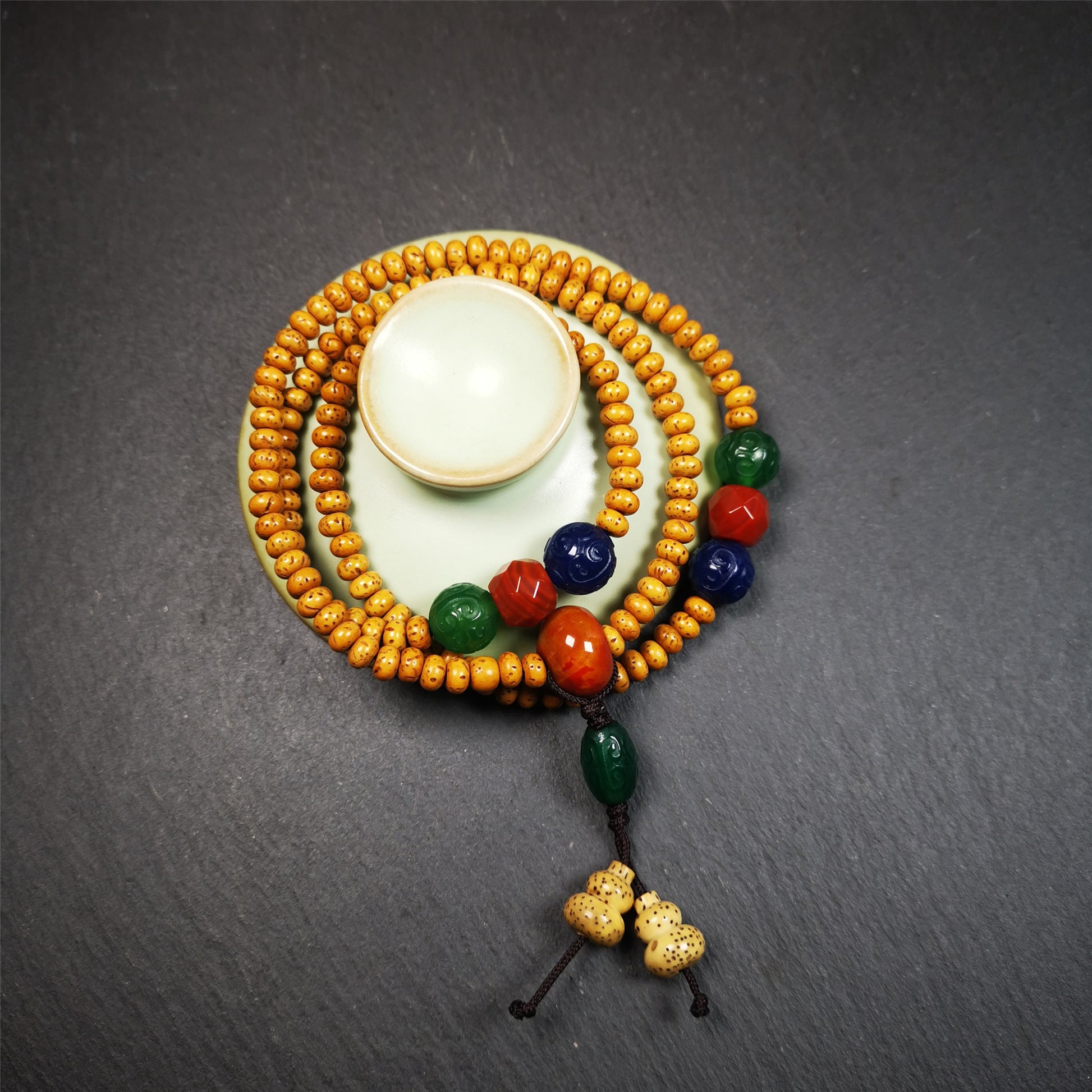 This mala is made by Tibetan craftsmen. It is composed of 108 lotus seed beads(5mm / 0.2"),perimeter is about 56cm,22inches.equipped with red, blue and green agates, very elegant.  It is worn with an elastic cord, so it fits the wrist very well, suitable for women to use as a bracelet mala