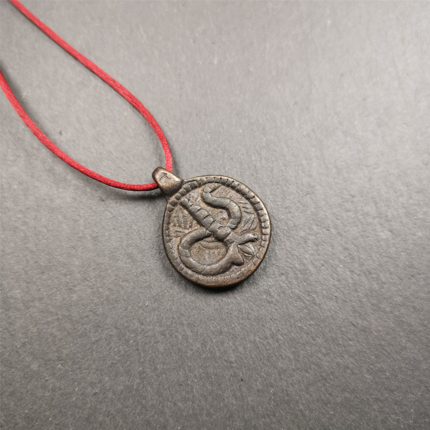 These amulet were  handmade by Tibetan craftsmen from Tibet in 1990's. It's made of copper/brass,brown/yellow color,diameter is 0.83 inch,comes with a leather cord. You can make it into a necklace,or bag hanging