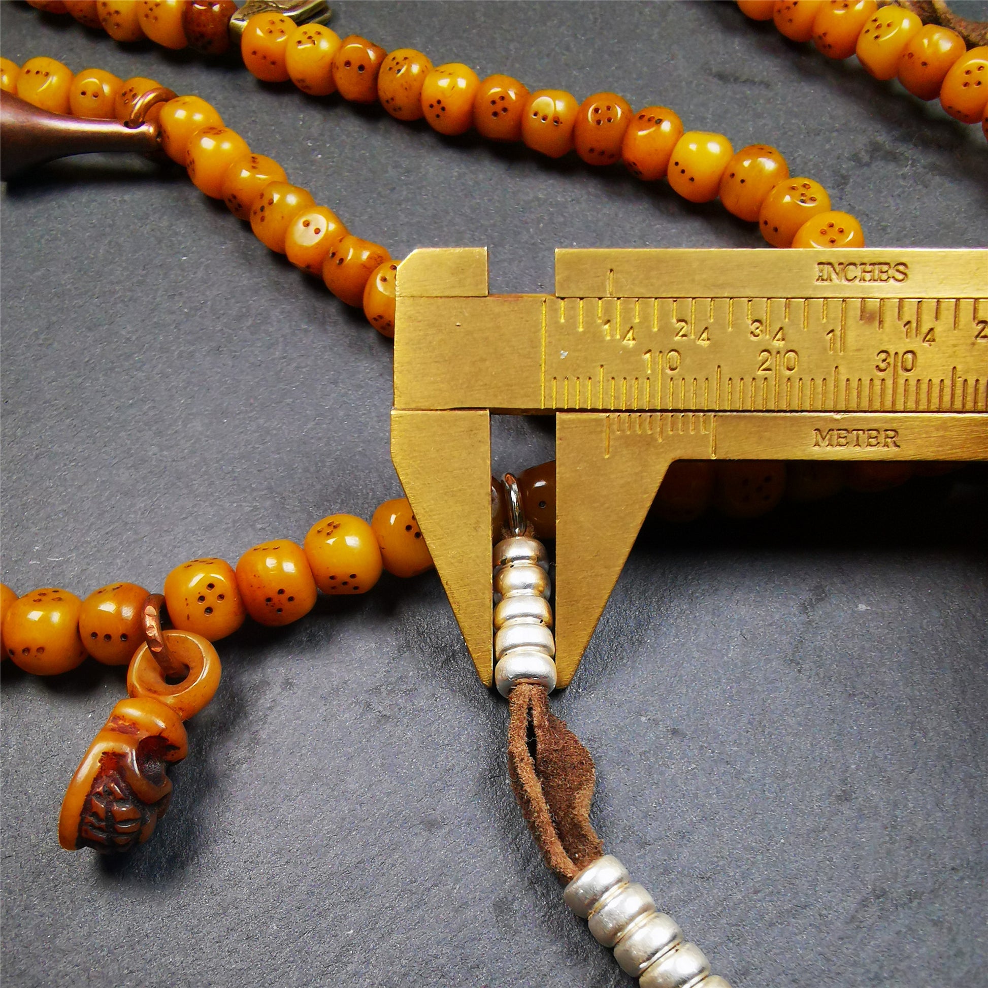 This mala bracelet was made by Tibetan craftsmen. It is made of yak bone, yellow color,108 dice beads diameter of 7mm / 0.27",circumference is 68cm / 26.8",and lots of accessories on it.