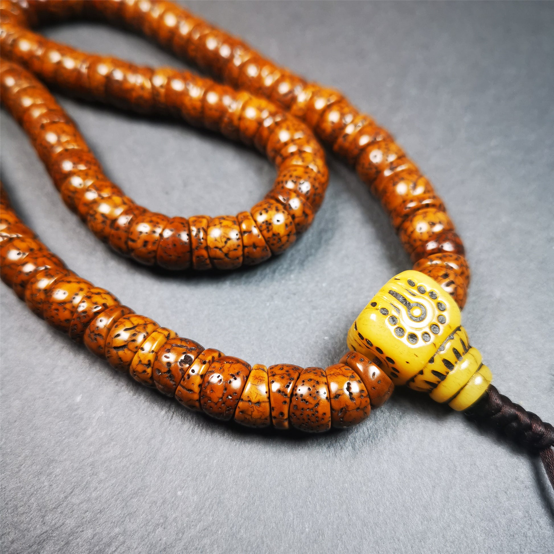 This lotus seed mala was collected from Baiyu county,about 40 years old,hold and blessed by a lama. It is composed of 108 bodhi seed beads, bevel cut shape,brown color,and 1 yak bone guru bead.