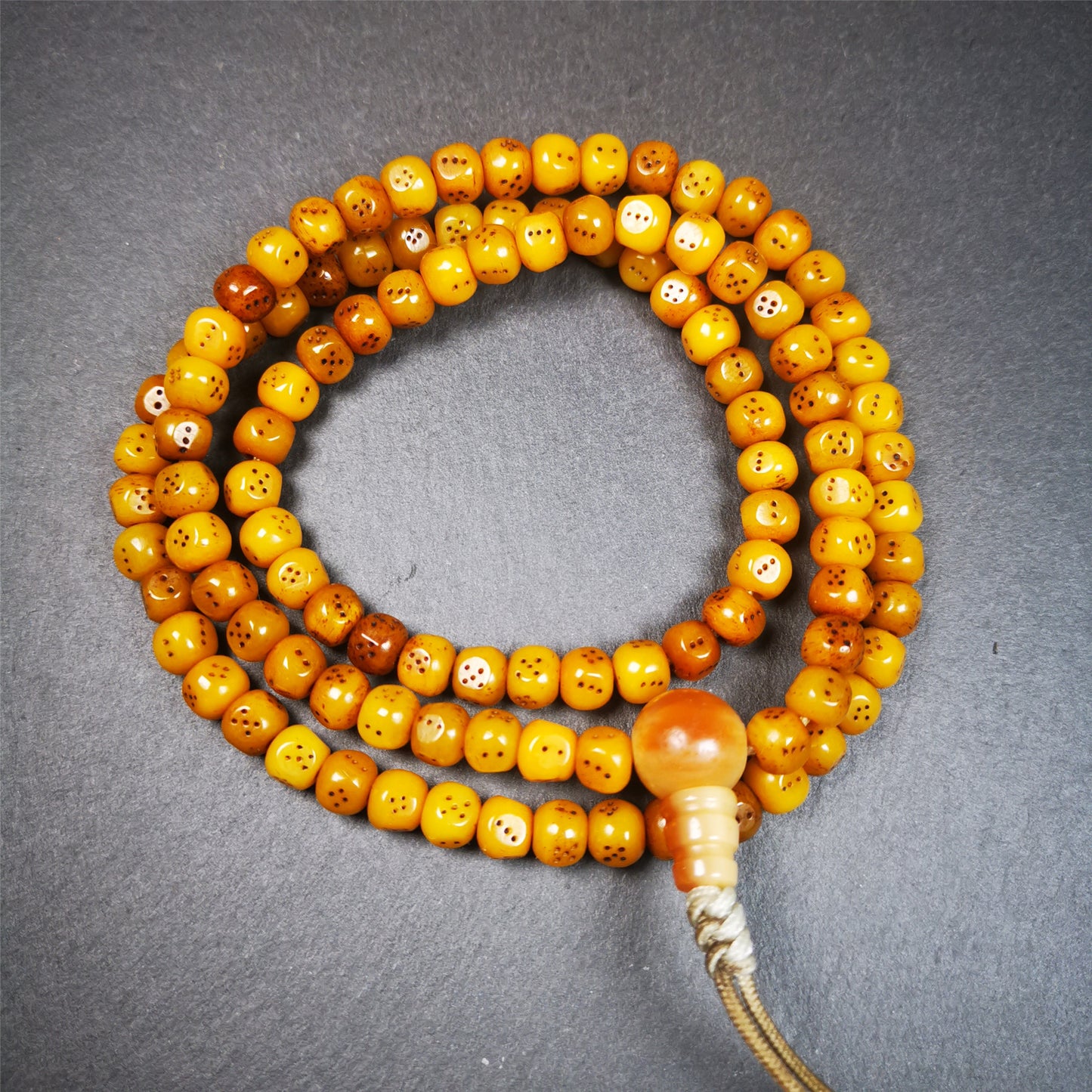 This mala bracelet was made by Tibetan craftsmen.  It is made of yak bone, yellow color,108 dice beads diameter of 7mm / 0.27",circumference is 68cm / 26.8" ,  end of a yak horn guru bead.